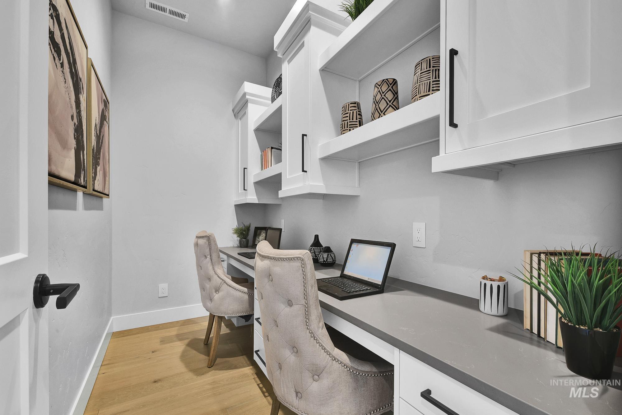 Office space featuring built in study area and light wood-style floors