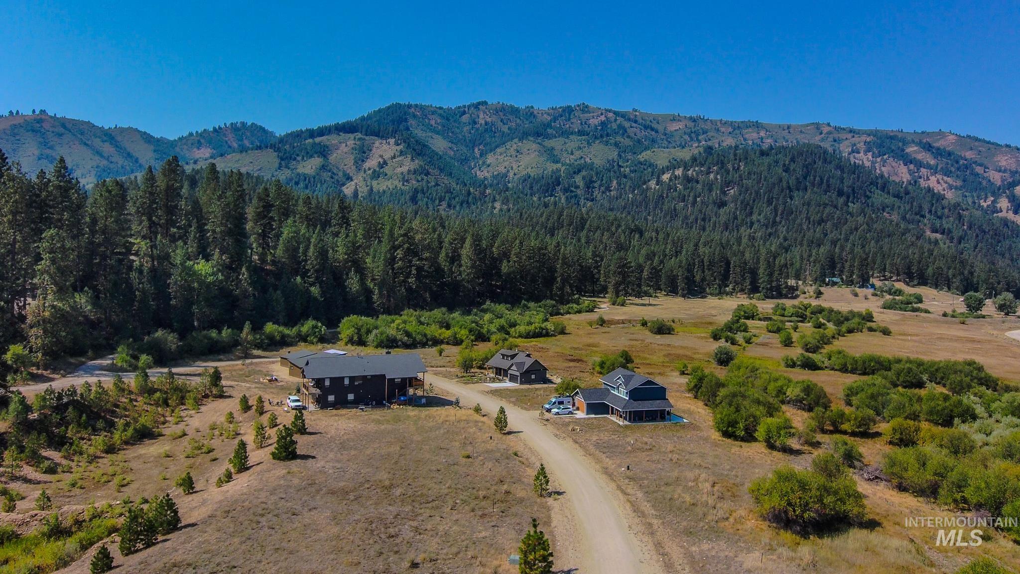 Aerial view of property and surrounding area with a heavily wooded area and mountains