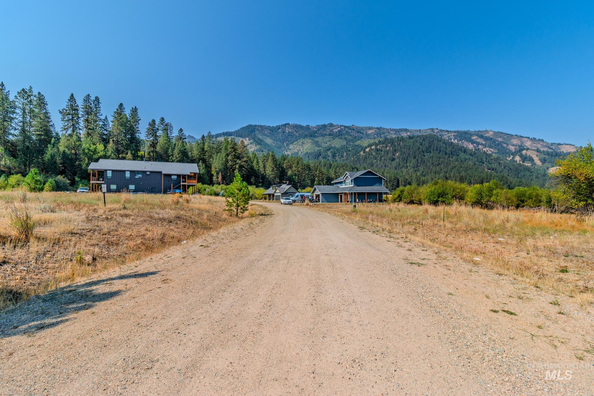 View of dirt / gravel road featuring a mountain view, a view of countryside, and a forest view