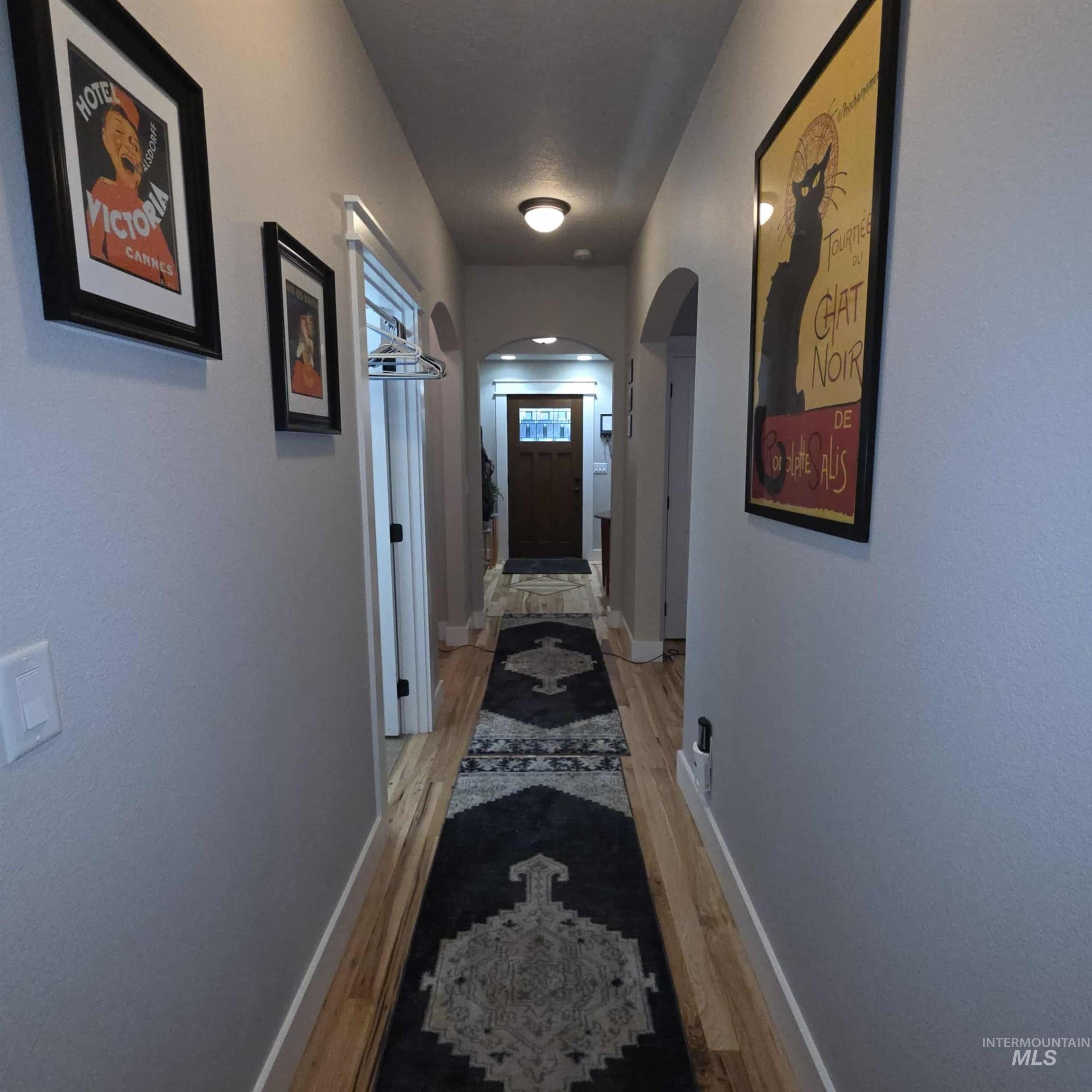 Hall featuring light wood-style flooring and arched walkways