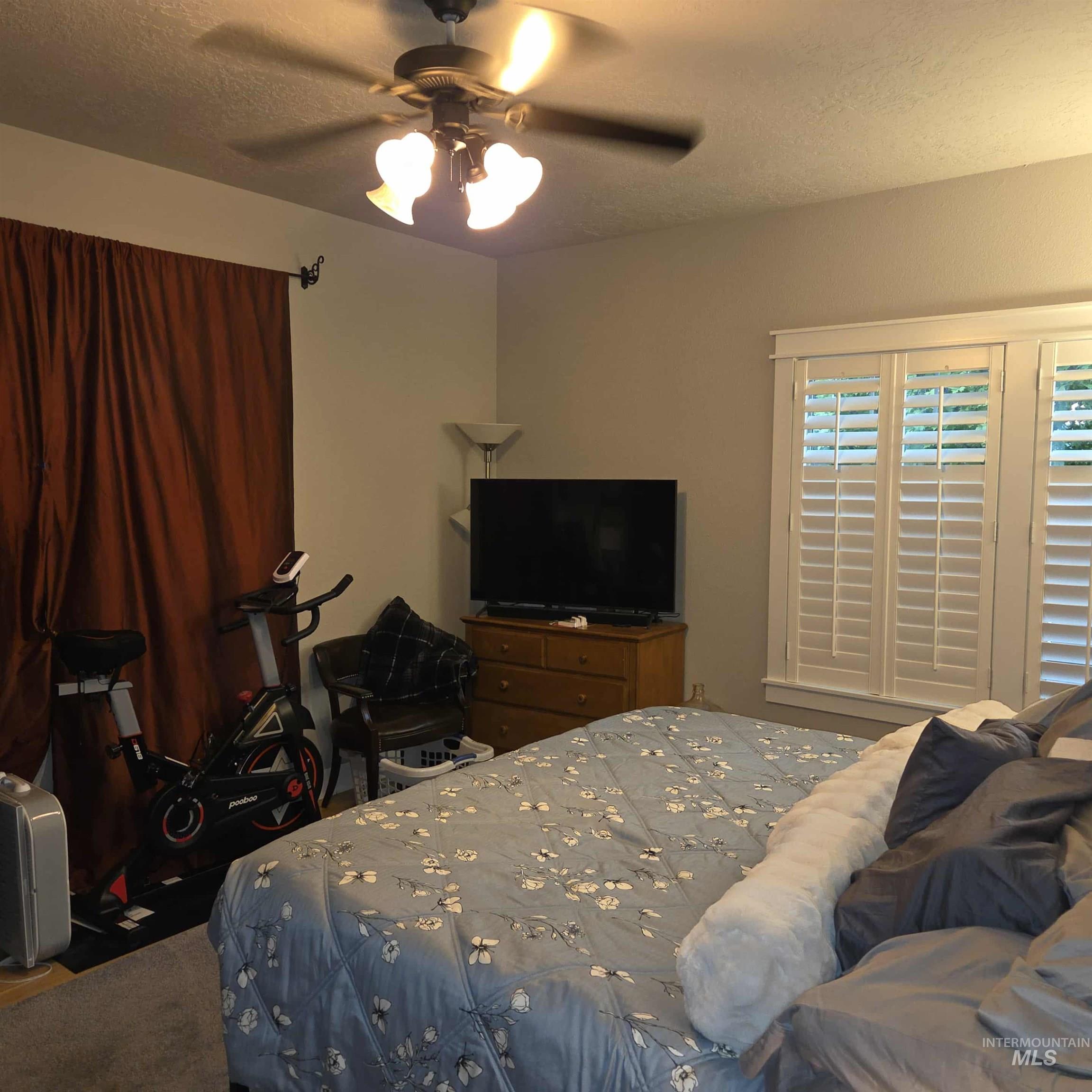 Bedroom featuring a textured ceiling and a ceiling fan