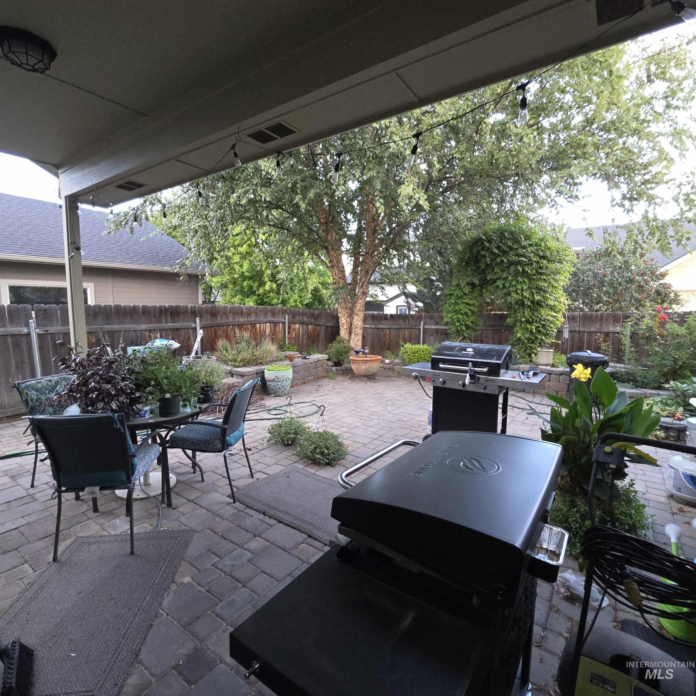 Fenced backyard with a patio area, grilling area, and outdoor dining space