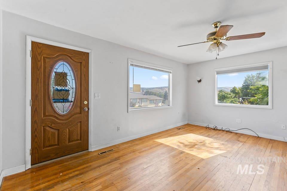 Foyer entrance with wood-type flooring and ceiling fan