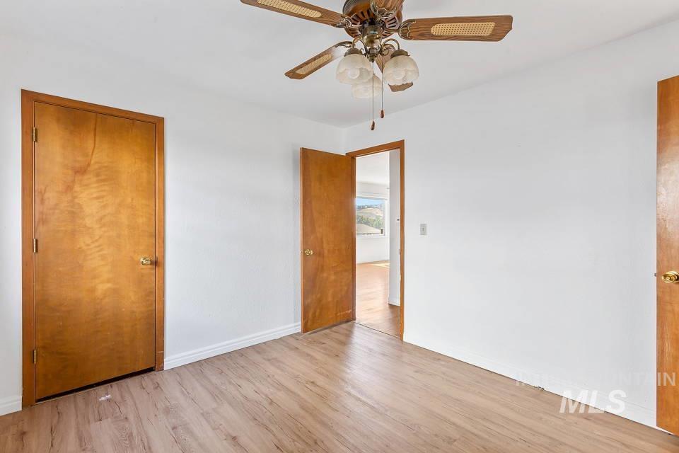 Unfurnished bedroom featuring light wood-type flooring and a ceiling fan