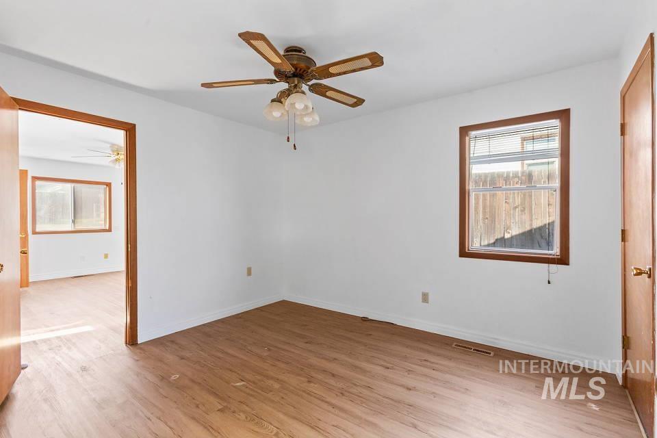 Unfurnished bedroom with light wood-style floors and a ceiling fan