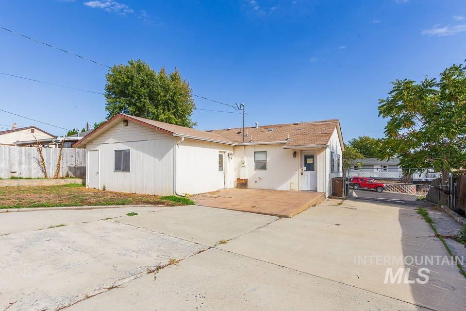 Rear view of house with concrete driveway and a gate