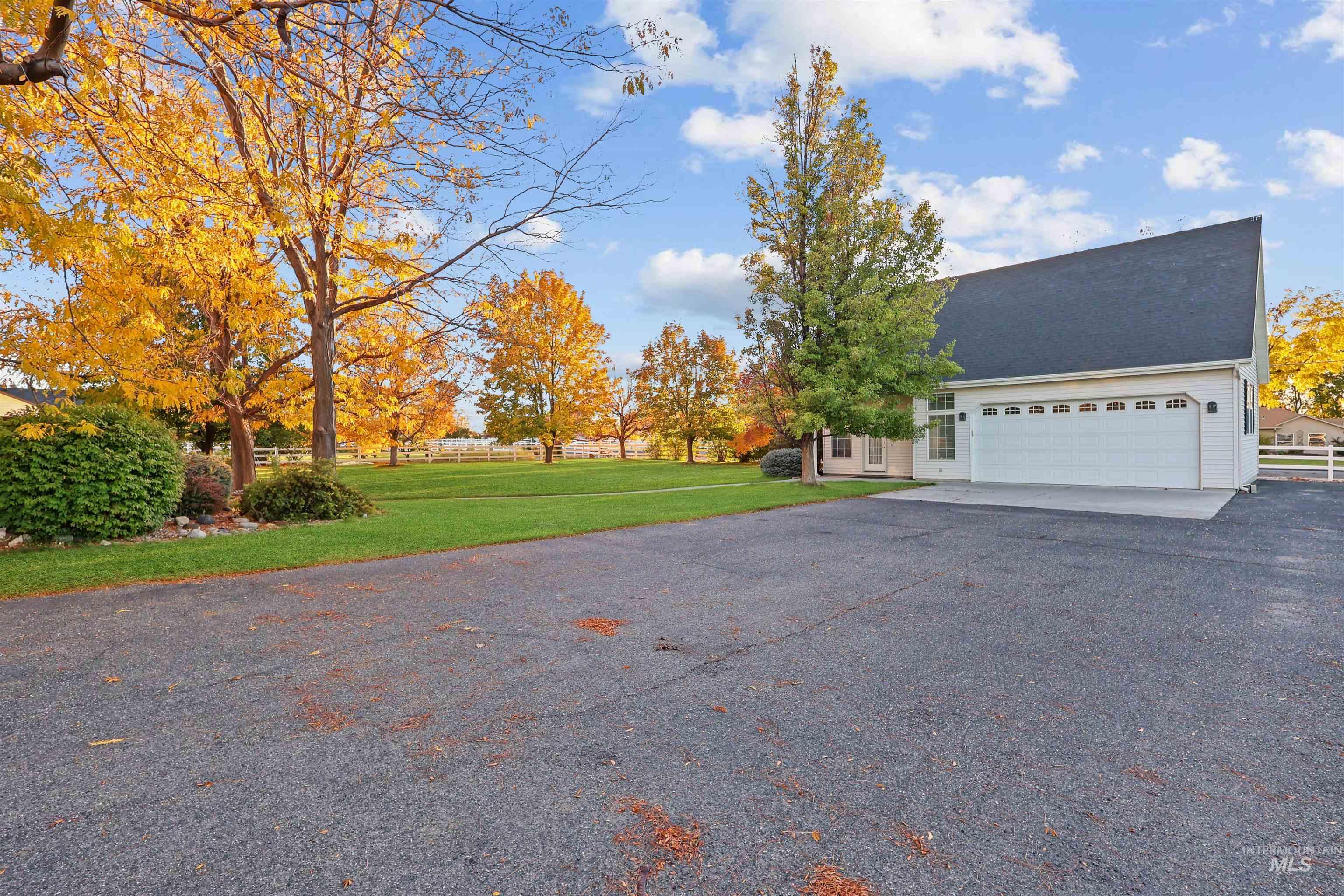 View of side of home with asphalt driveway and an attached garage