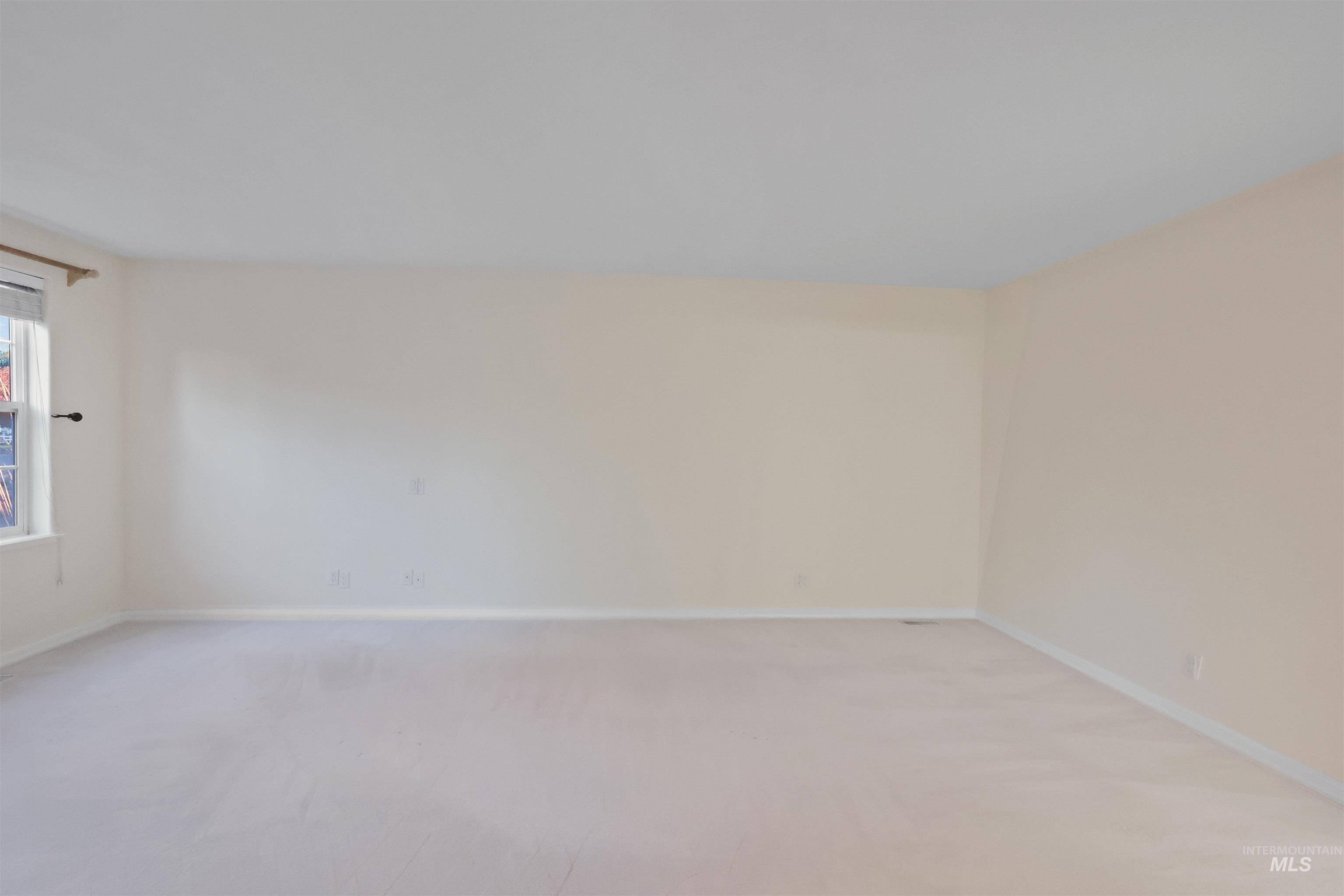 Empty room featuring light carpet