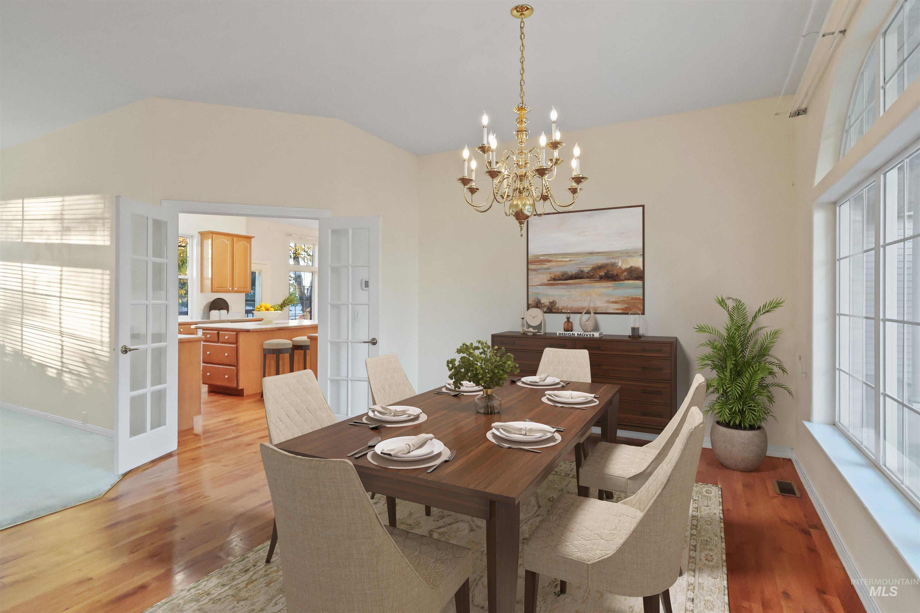 Dining space with french doors, a chandelier, light wood-style floors, and lofted ceiling