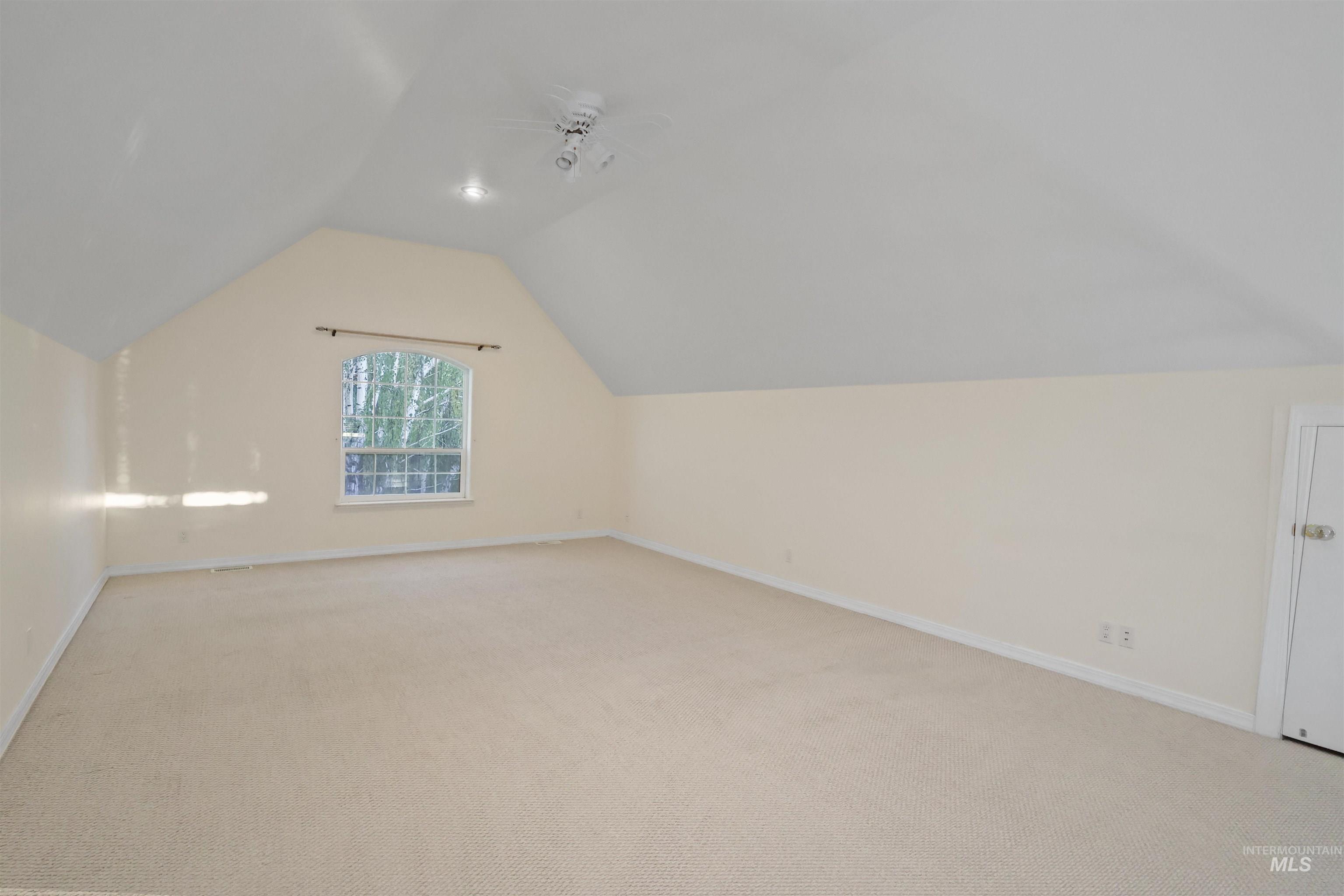 Bonus room featuring vaulted ceiling and light carpet