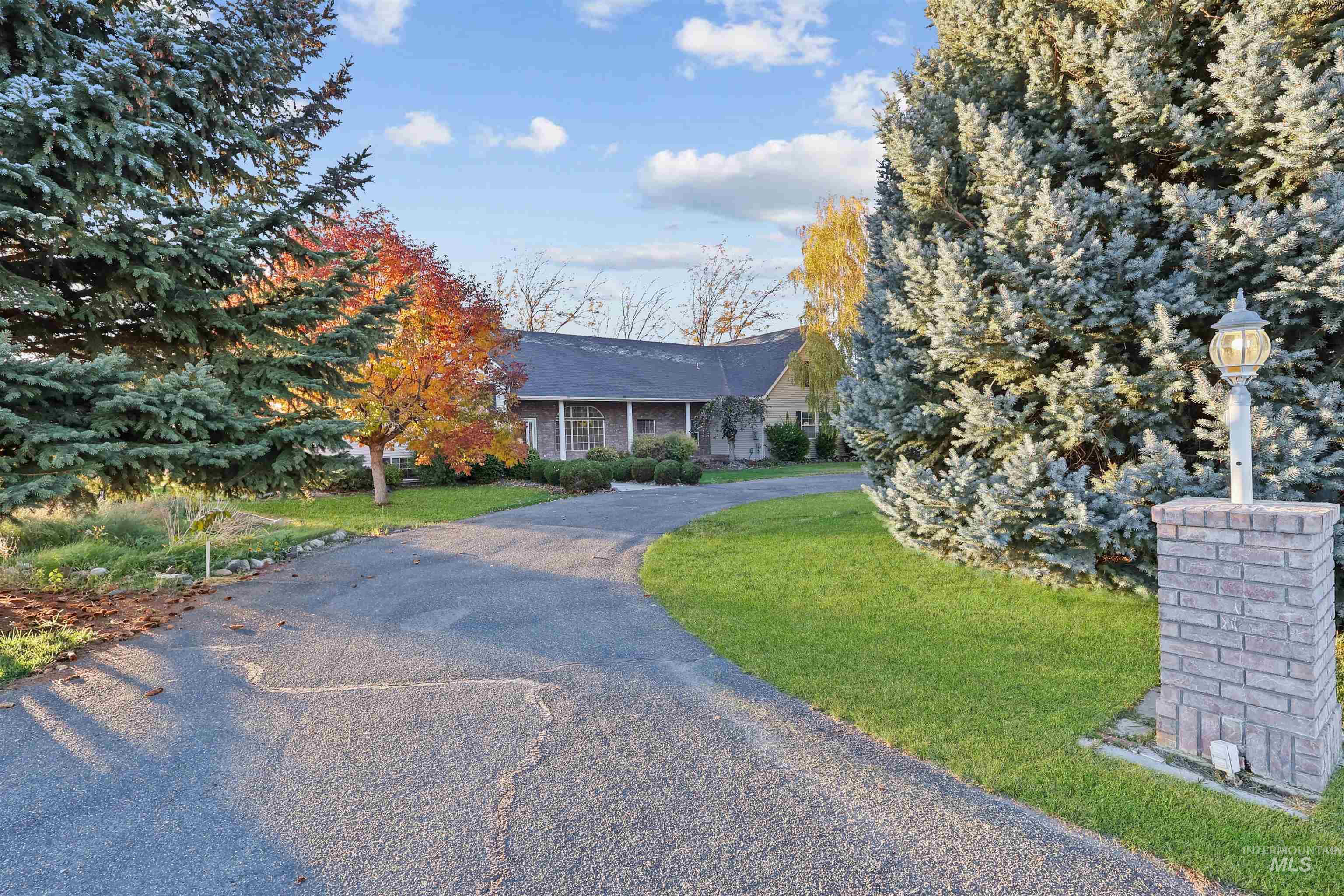 View of front of house featuring a front yard, asphalt driveway, and covered porch