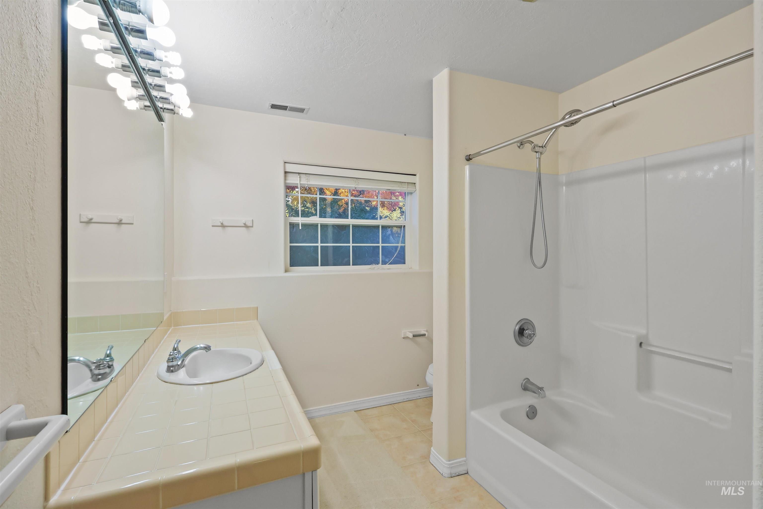 Bathroom featuring vanity and  shower combination