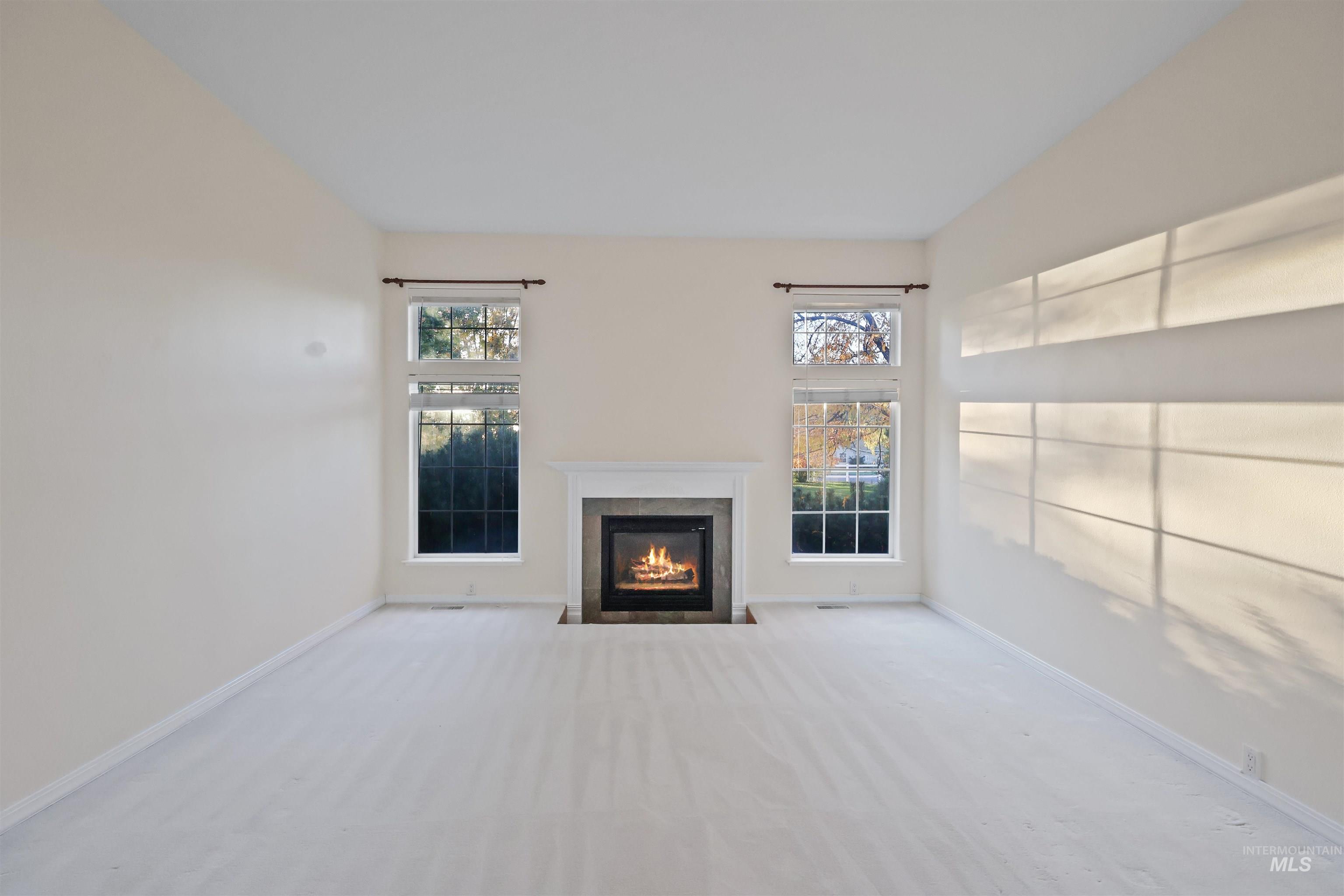 Unfurnished living room featuring a premium fireplace and carpet floors