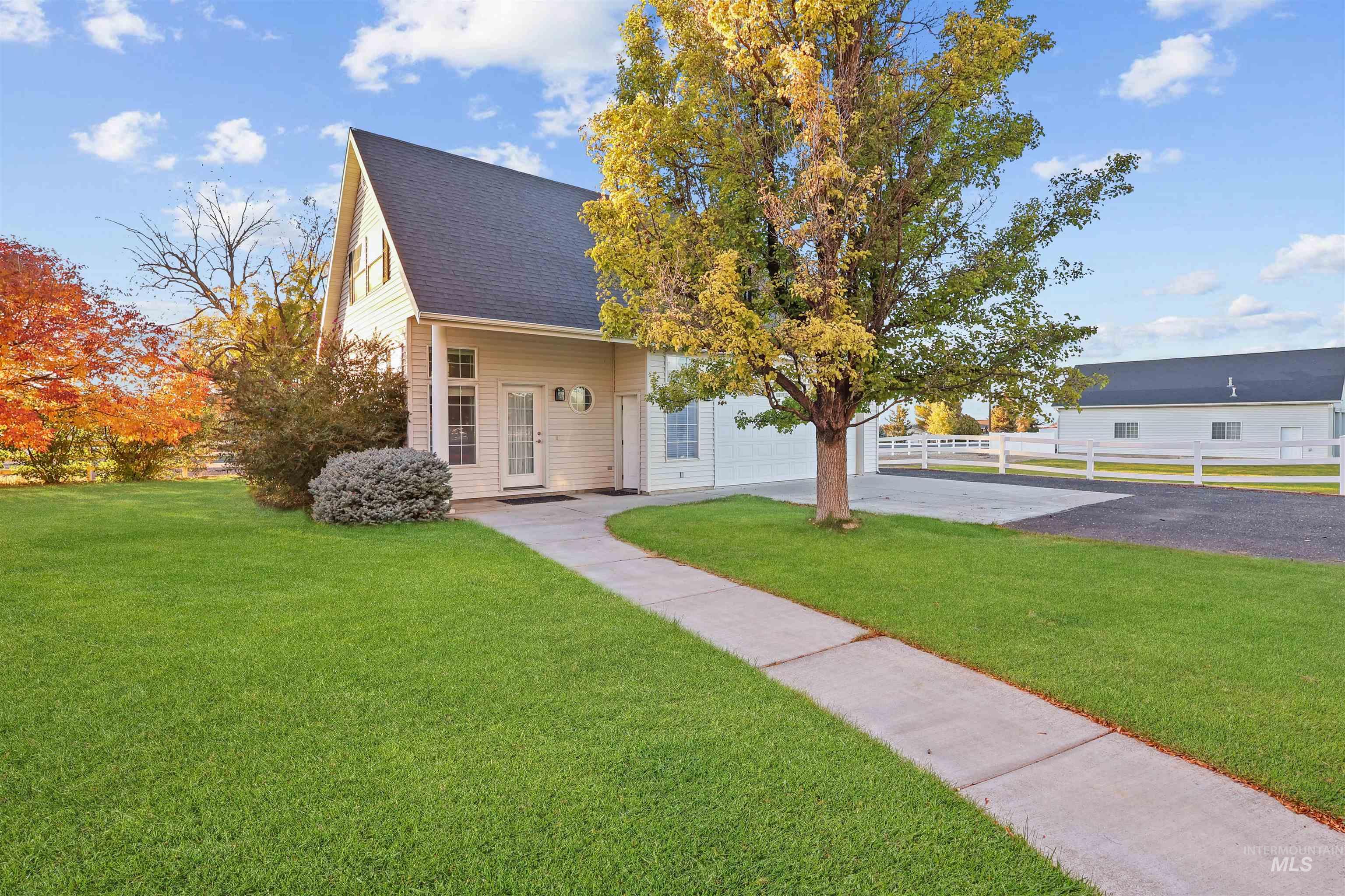 View of front facade with driveway, a shingled roof, and a garage