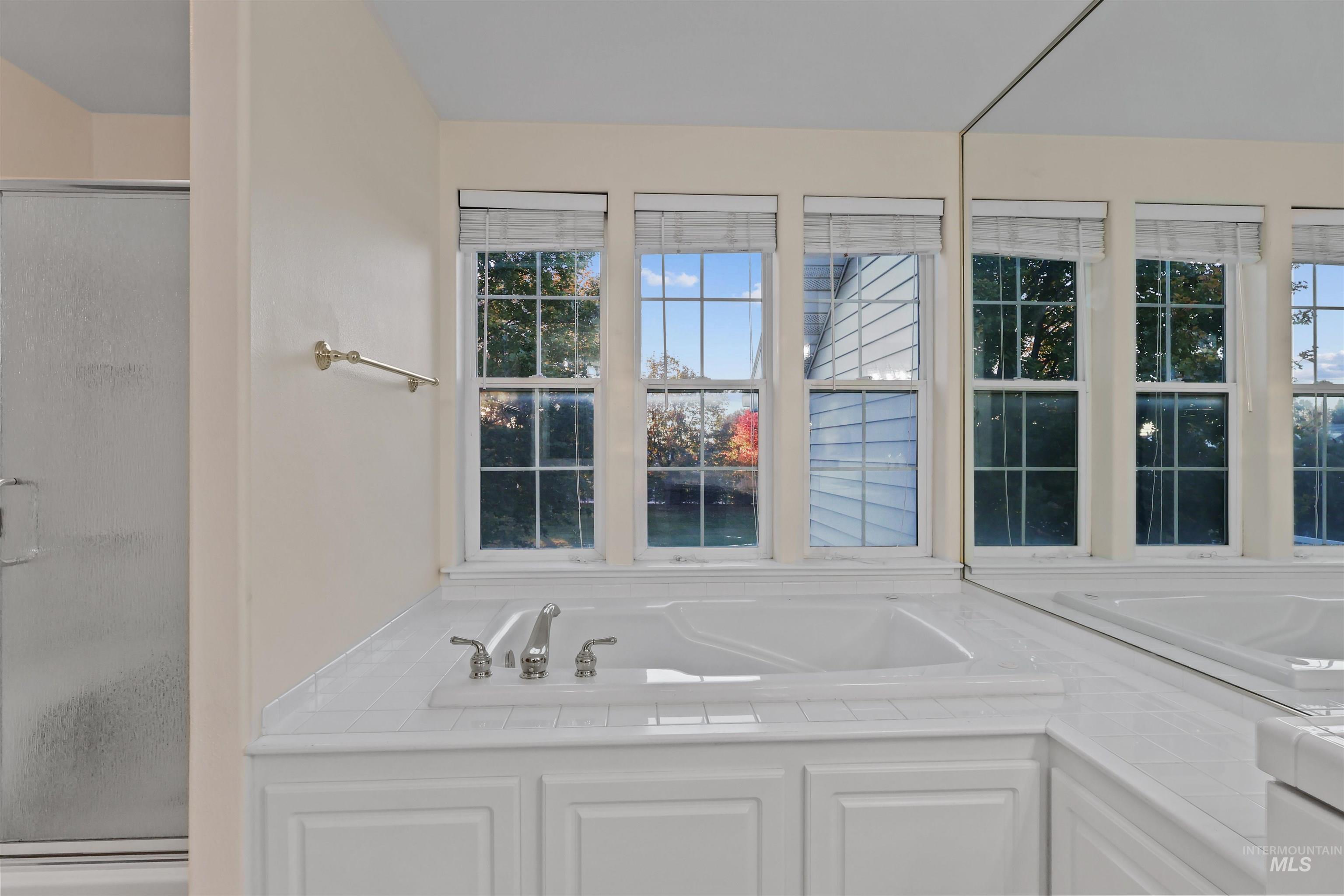 Full bath with a shower stall and a bath