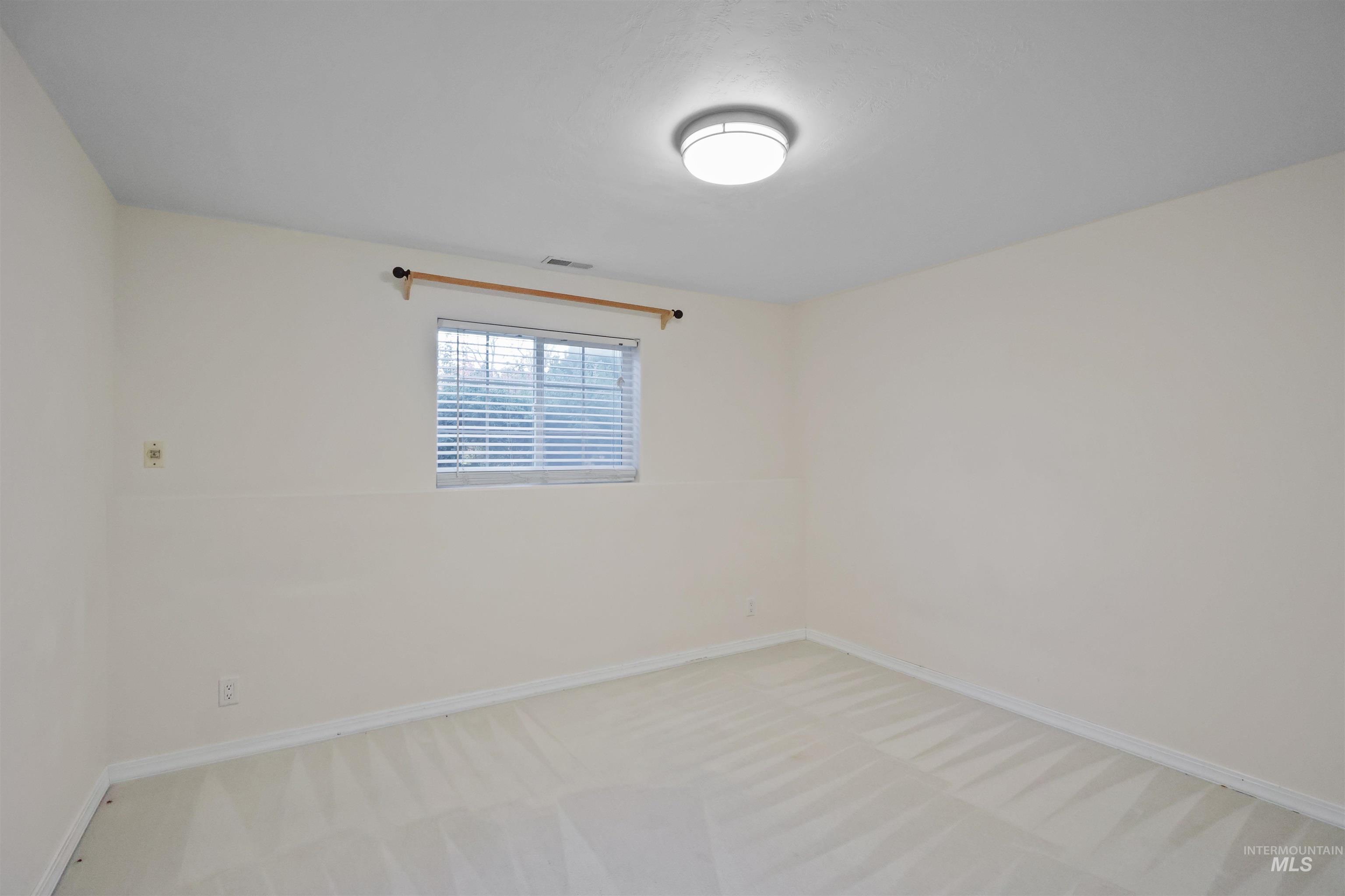 Spare room featuring baseboards and carpet flooring