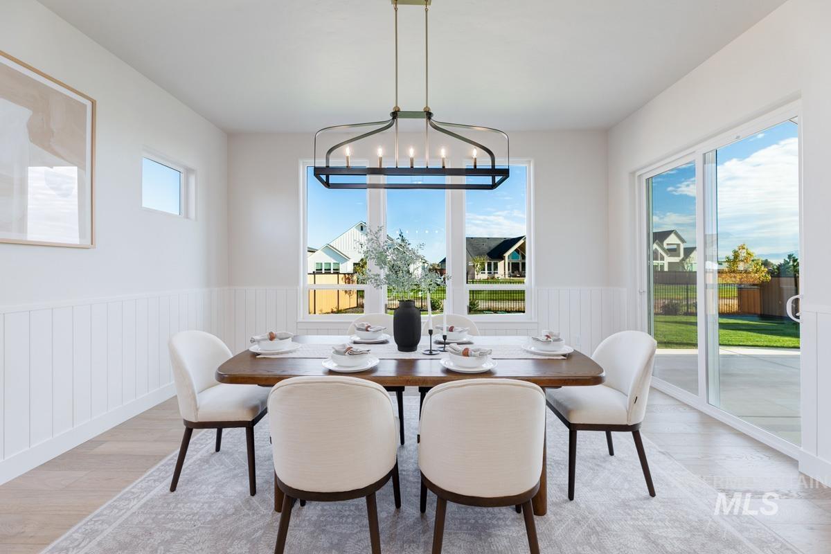 Dining room featuring light wood-type flooring and a wainscoted wall