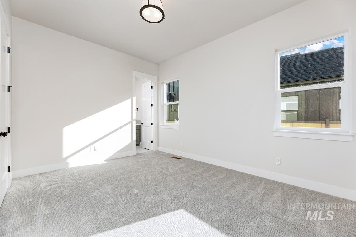 Carpeted spare room featuring baseboards