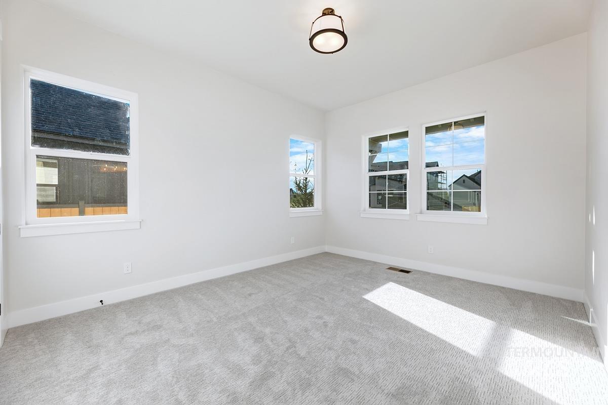 Empty room featuring healthy amount of natural light and carpet flooring