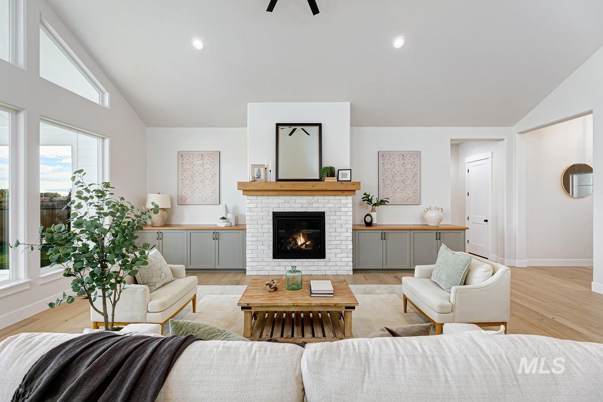 Living area featuring lofted ceiling, a fireplace, recessed lighting, and light wood-style flooring