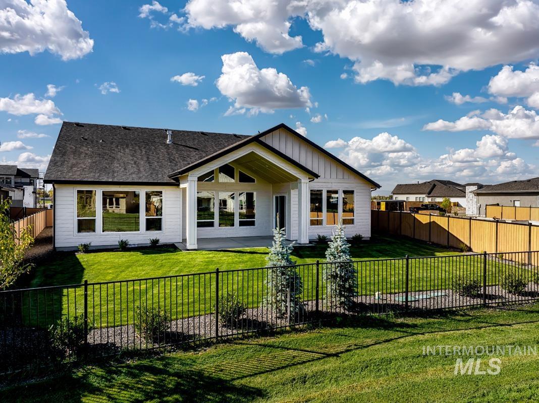 Back of property with a fenced backyard, a patio, board and batten siding, and roof with shingles