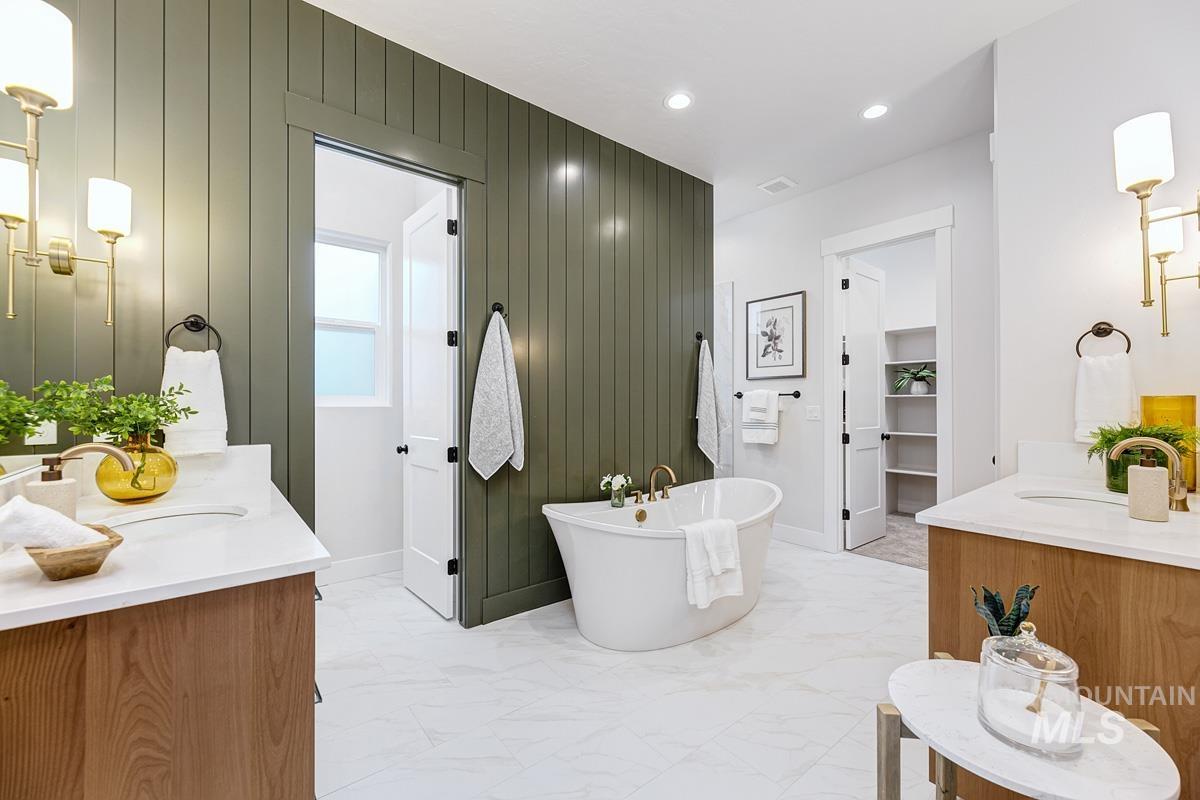Bathroom featuring vanity, a soaking tub, light marble finish flooring, recessed lighting, and wooden walls