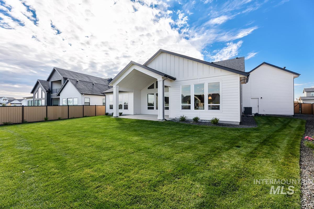 Back of property with a fenced backyard, a patio, and board and batten siding