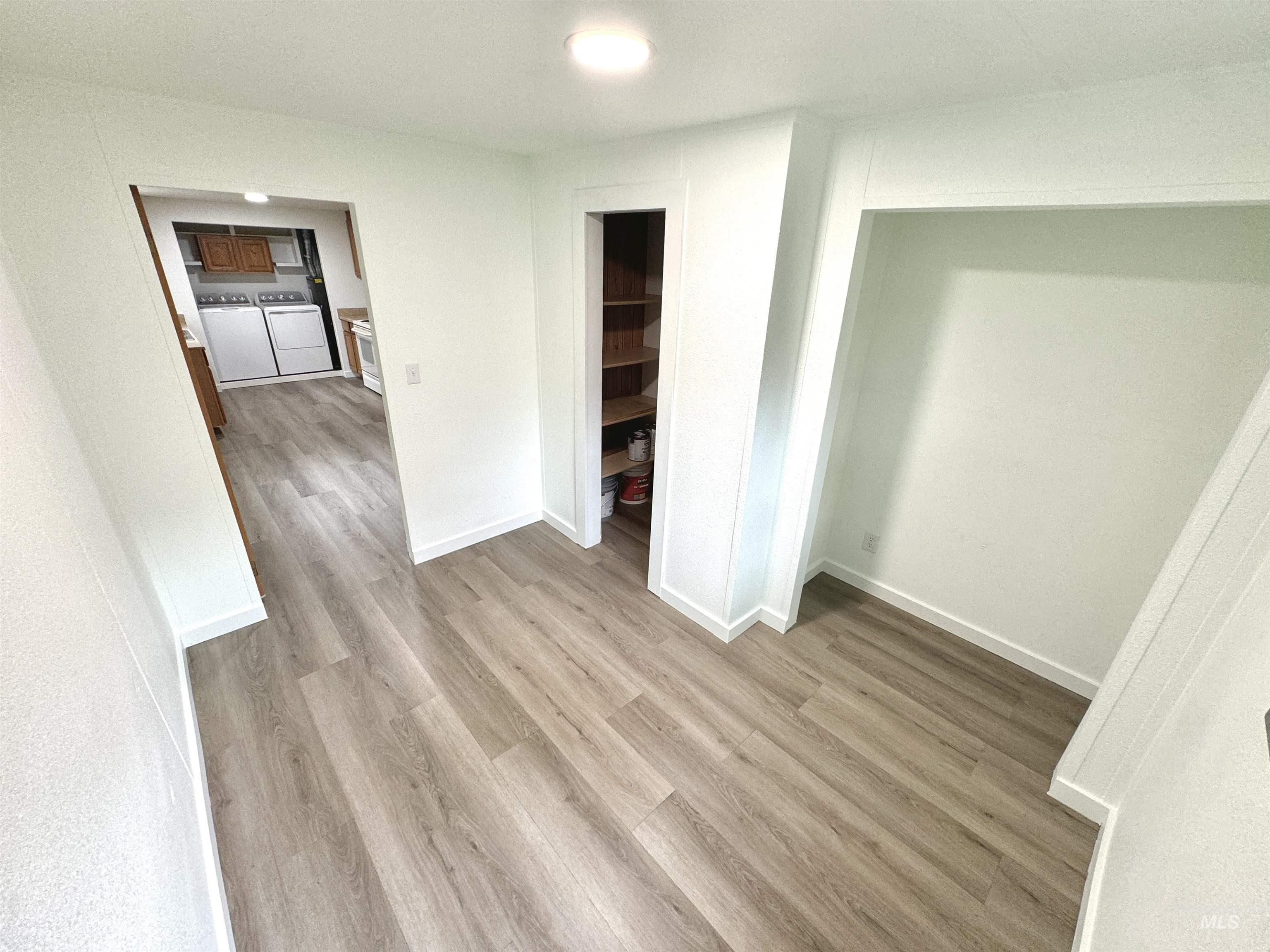 Unfurnished bedroom with light wood-style floors and washing machine and dryer