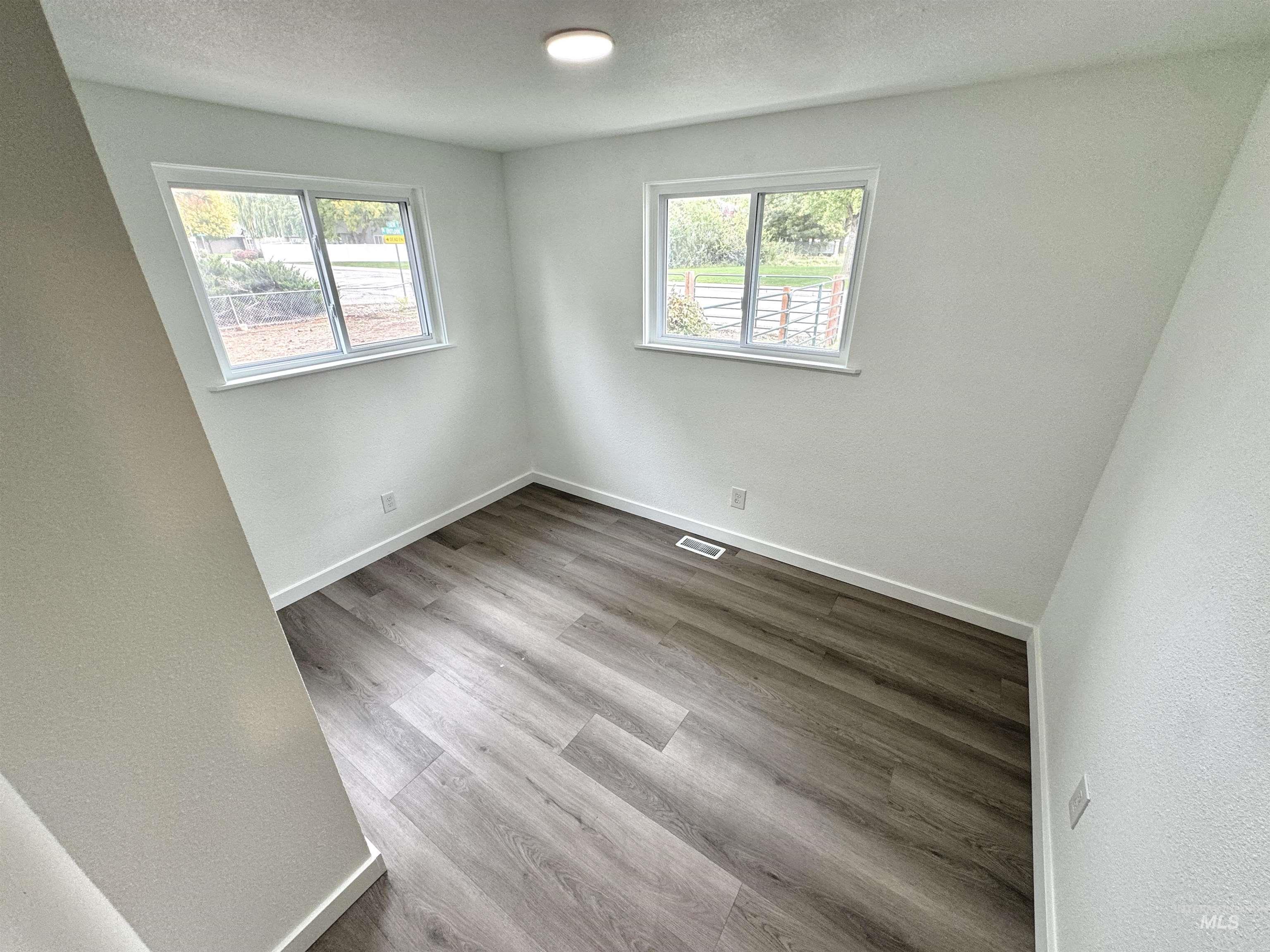 Empty room with light wood-type flooring and a textured ceiling