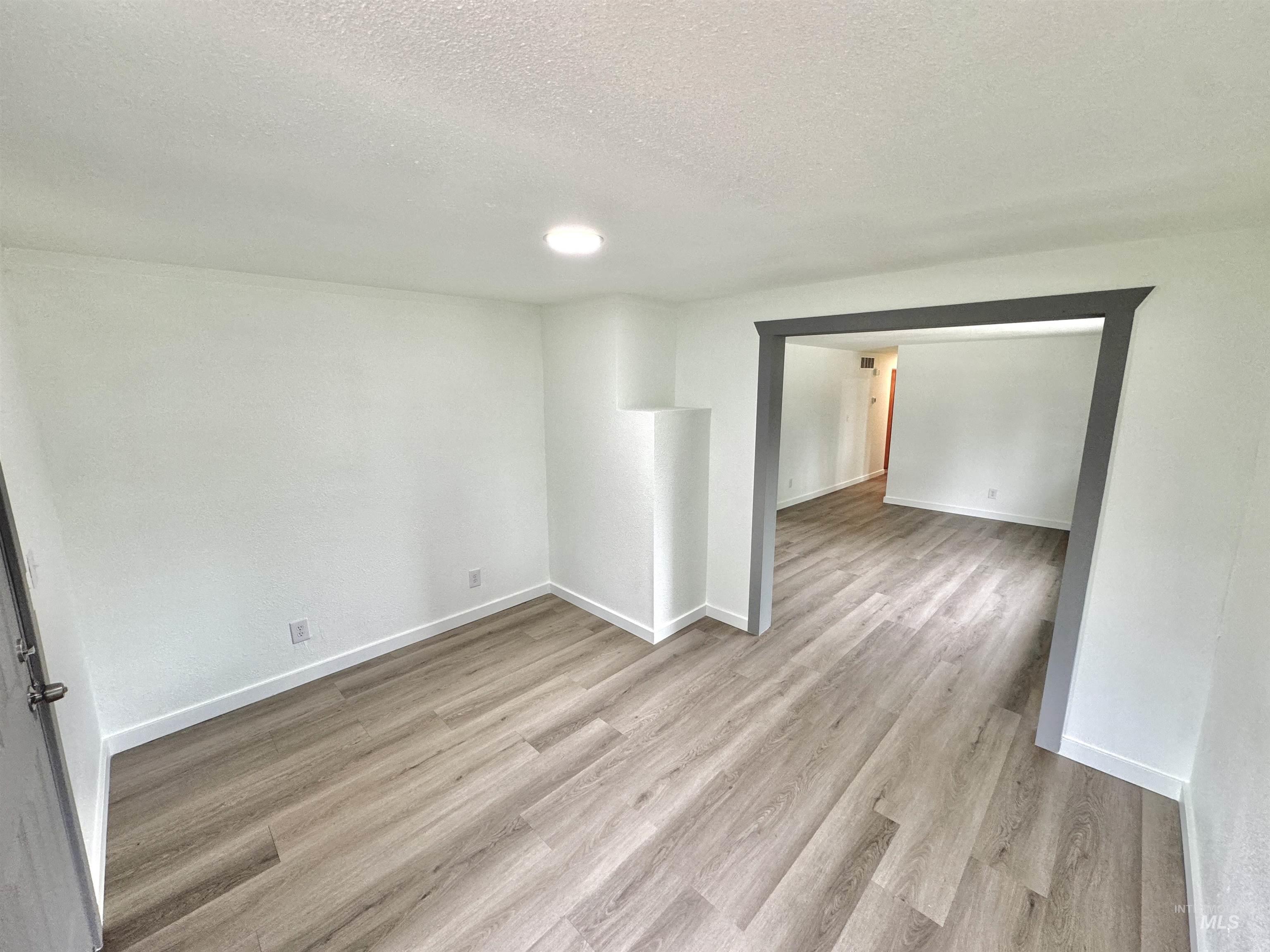Spare room with light wood-style flooring and a textured ceiling