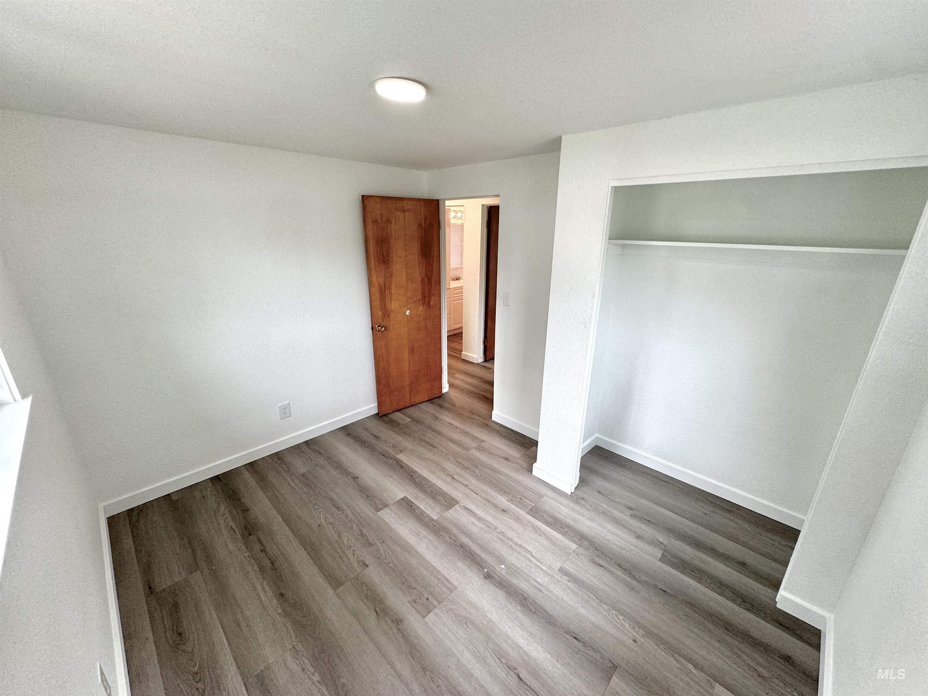 Unfurnished bedroom with light wood-style floors and a closet