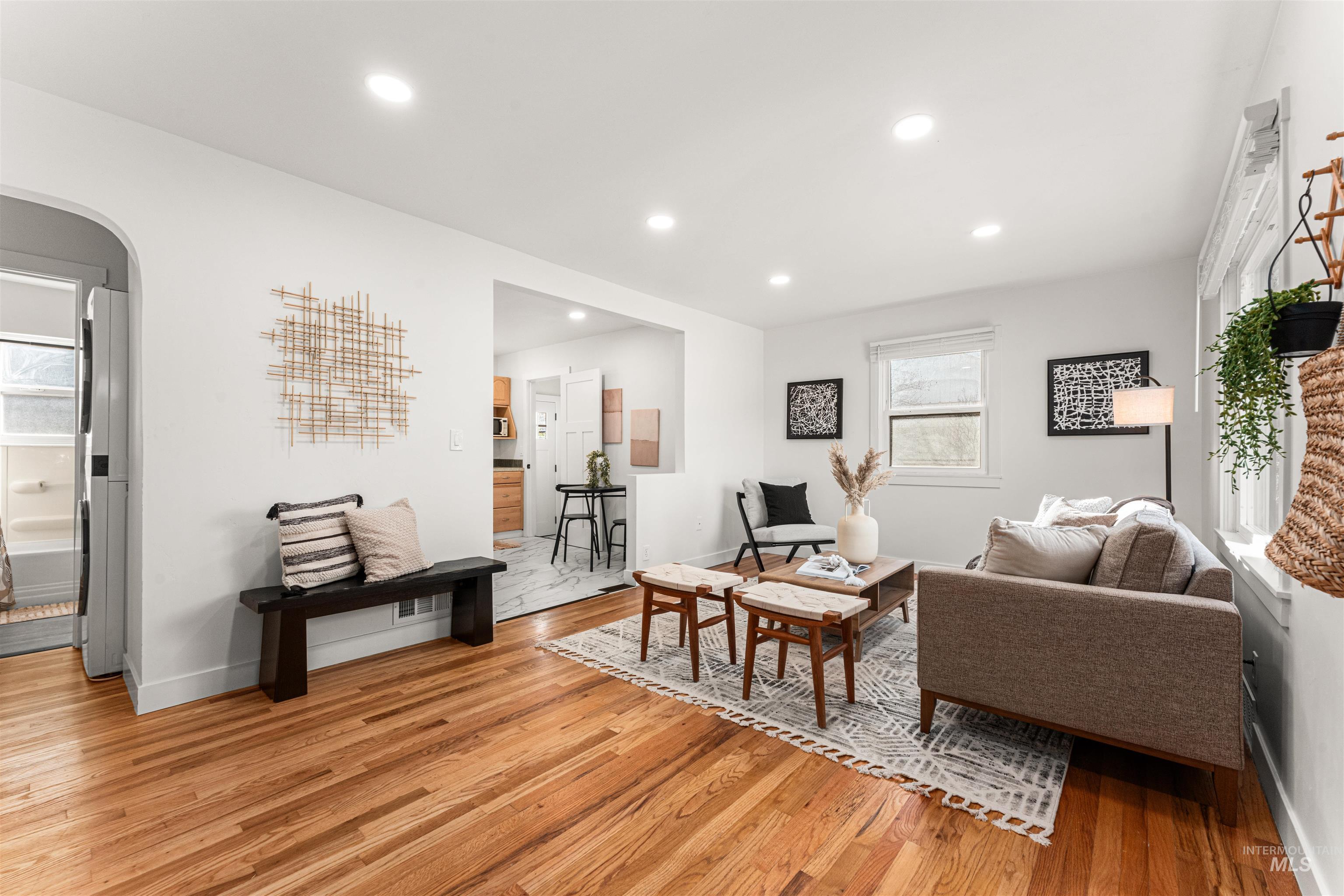 Living room with arched walkways, recessed lighting, and light wood-type flooring