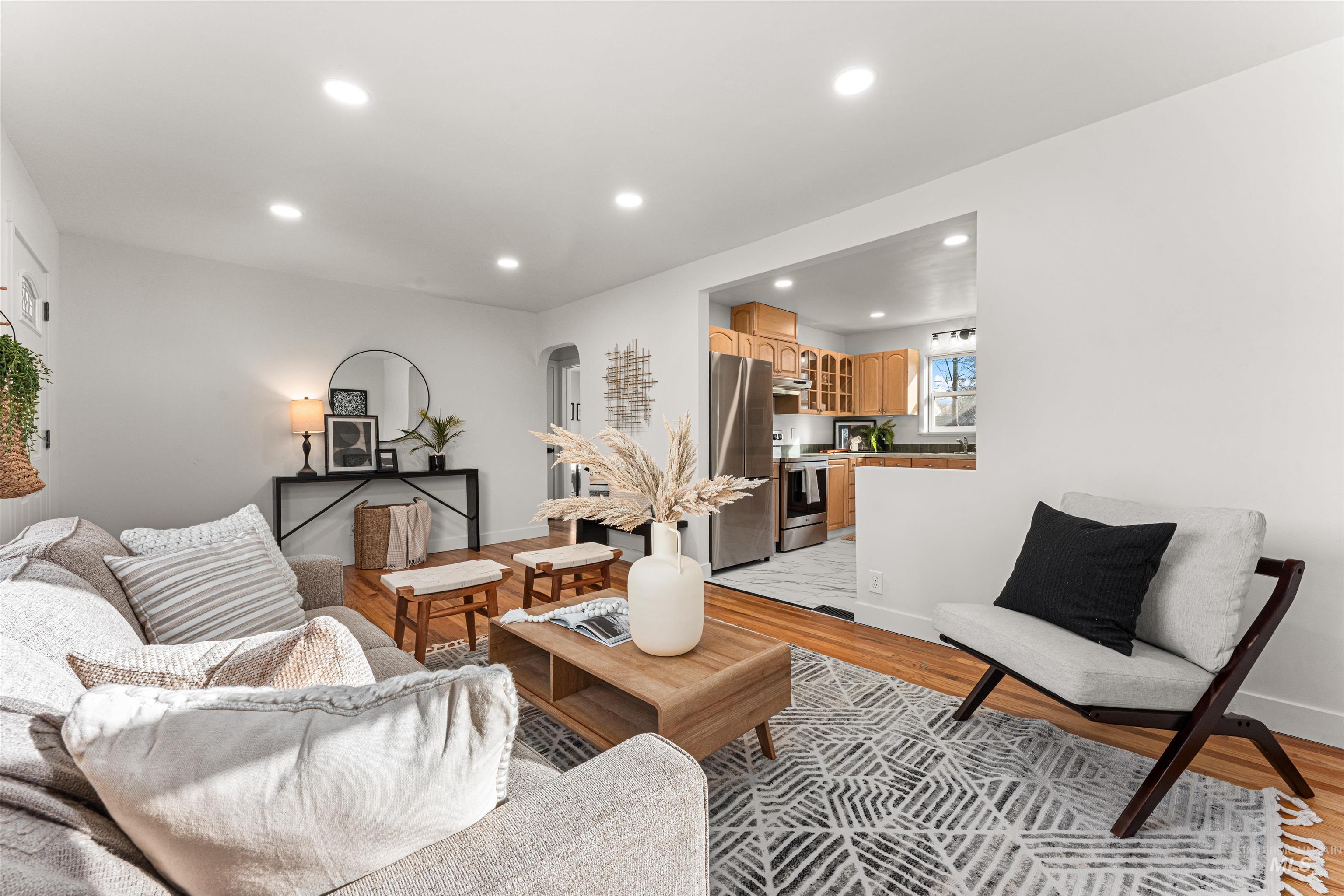 Living area with light wood-type flooring and recessed lighting