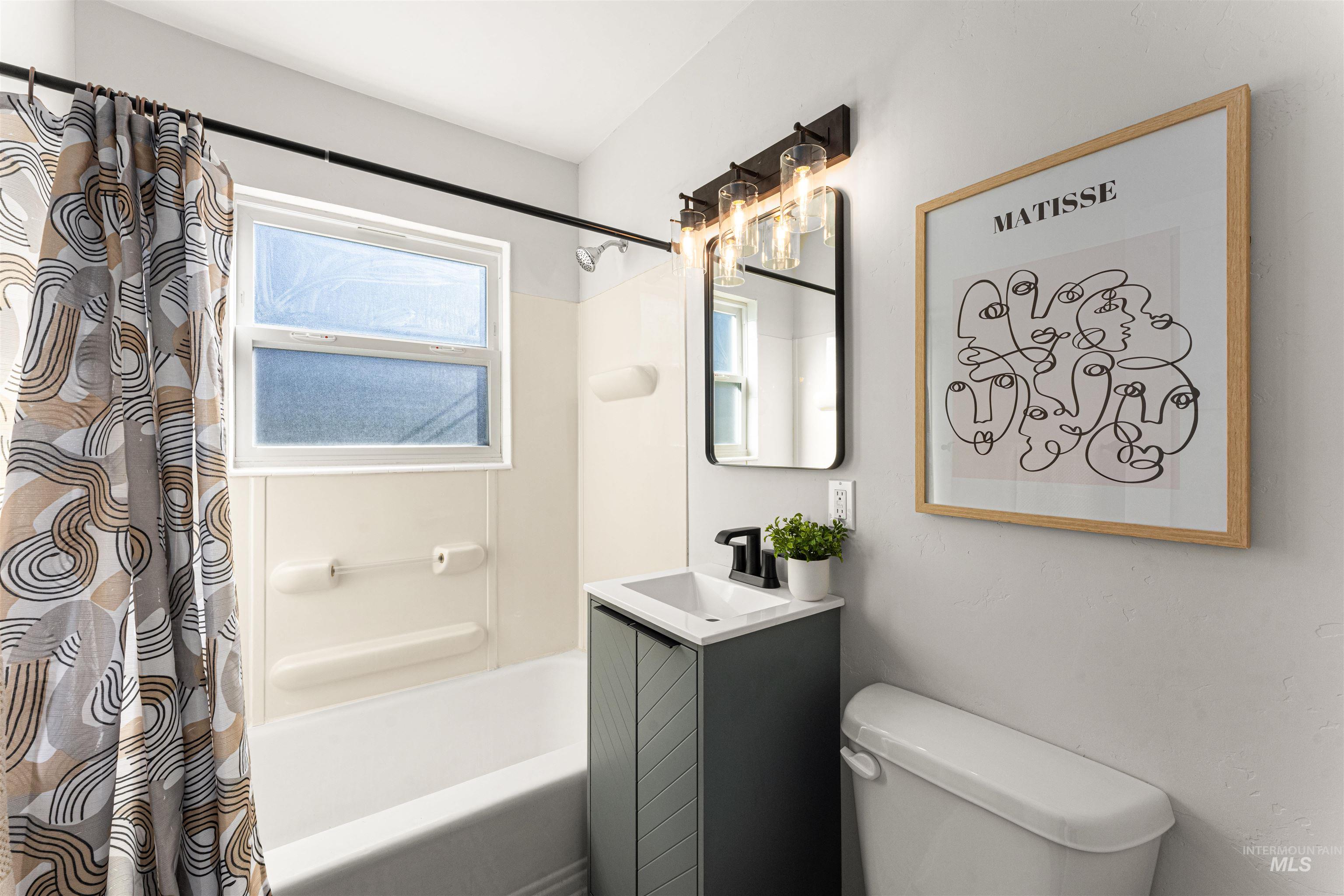 Full bathroom featuring vanity, shower / bath combo with shower curtain, stacked washing machine and dryer, and wood finished floors
