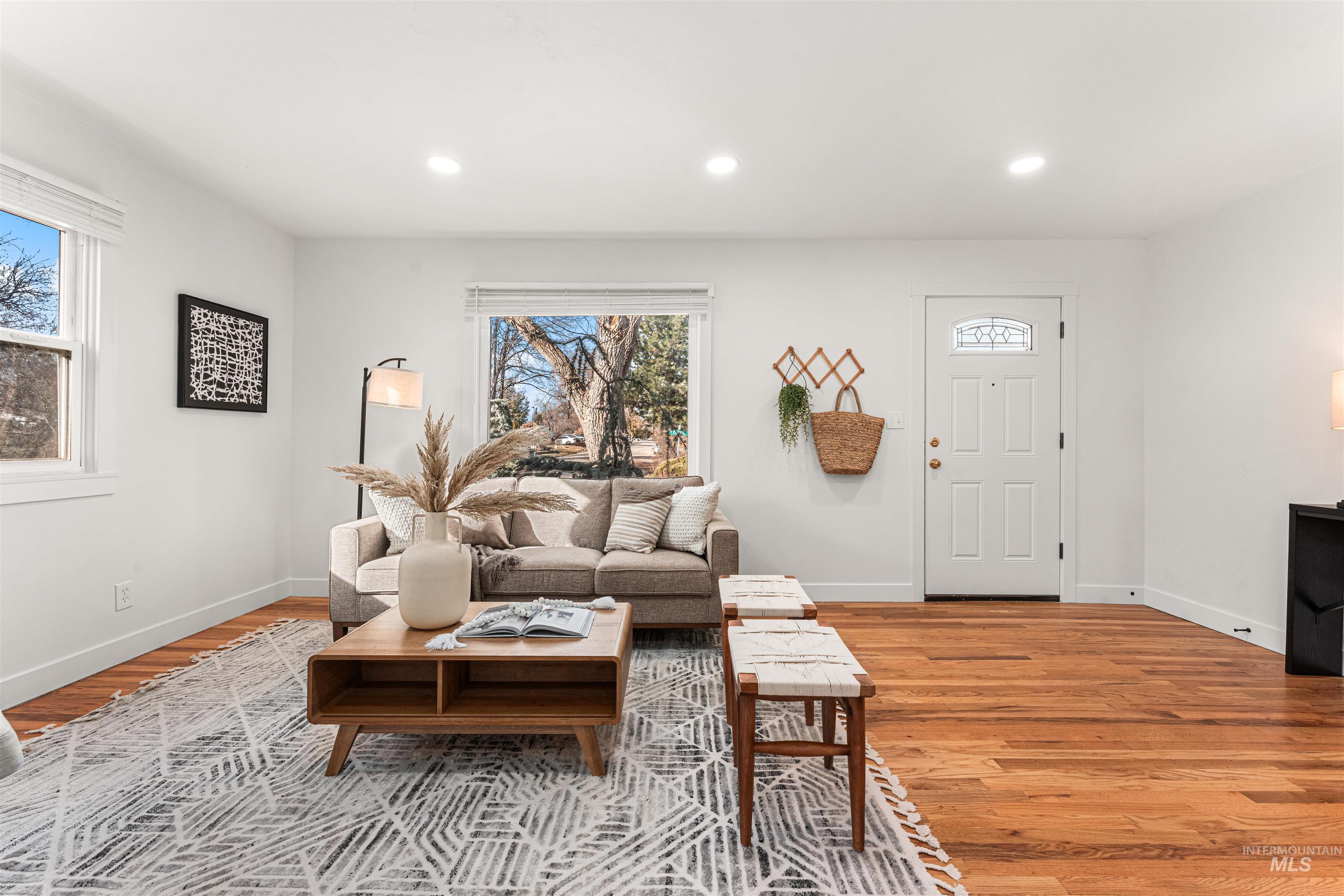 Living room with light wood-style flooring and recessed lighting