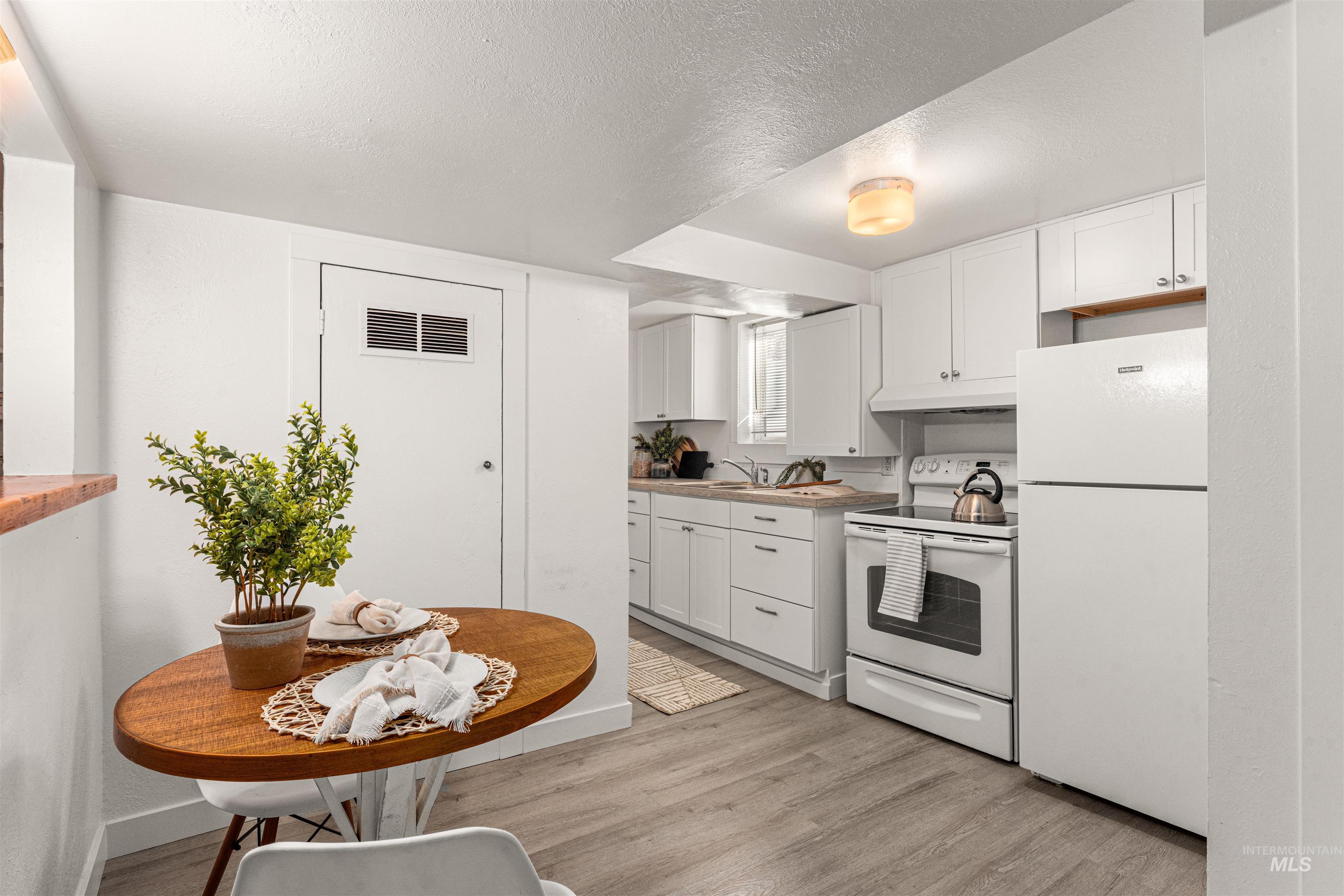 Unfurnished room featuring dark wood finished floors, a textured ceiling, and wood walls