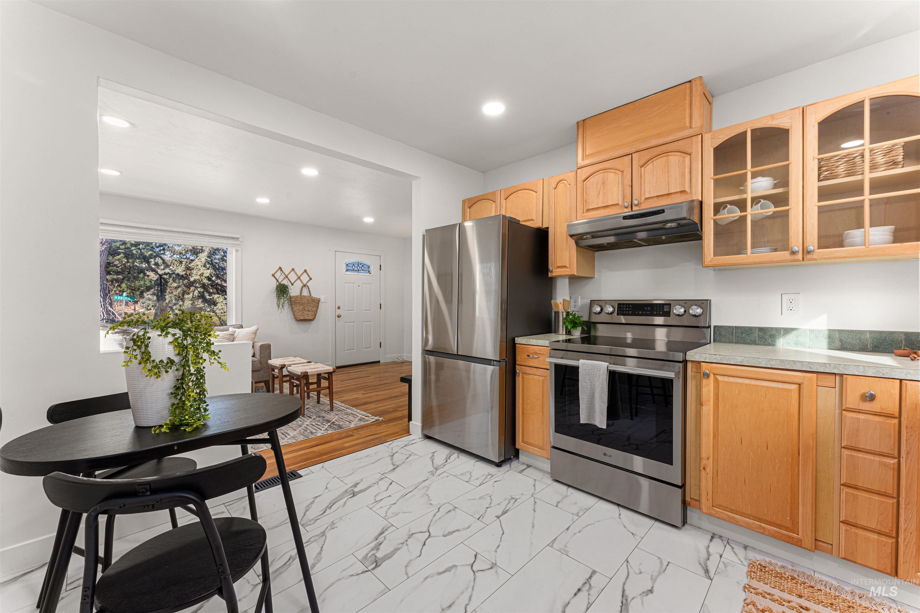 Bungalow-style house with a chimney, a shingled roof, and a front lawn