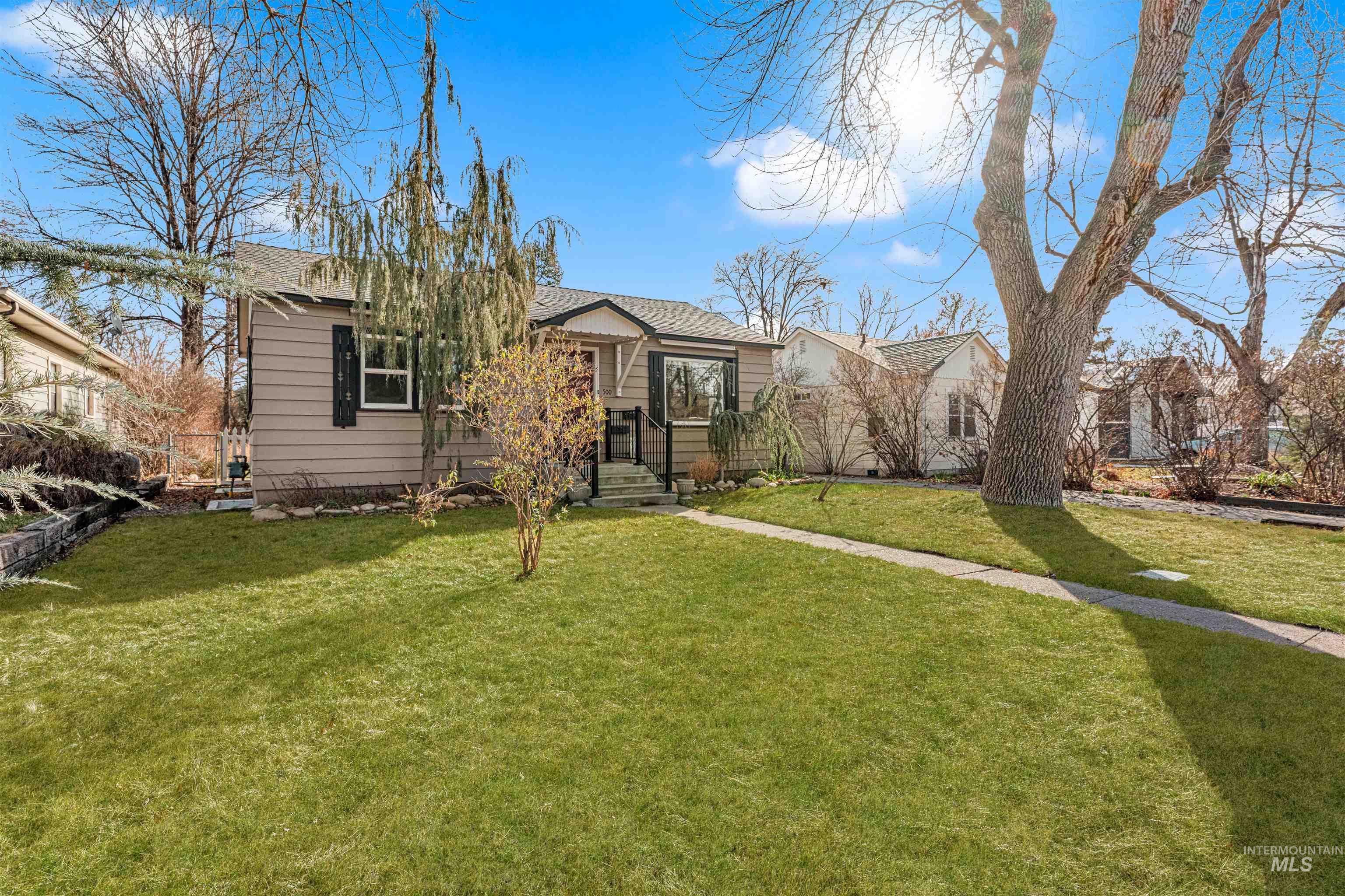 View of front of house with a front lawn and a shingled roof