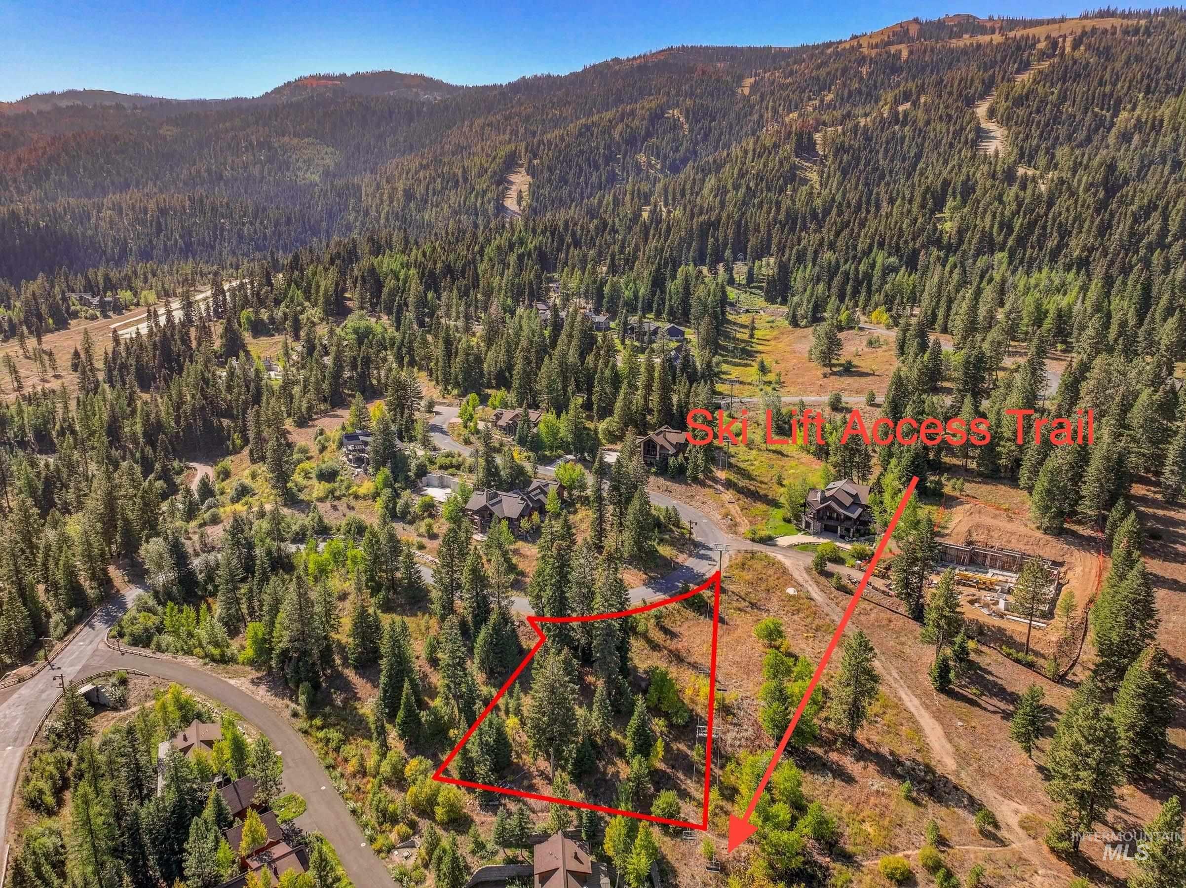 Aerial view of property and surrounding area featuring property parcel outlined and a mountainous background