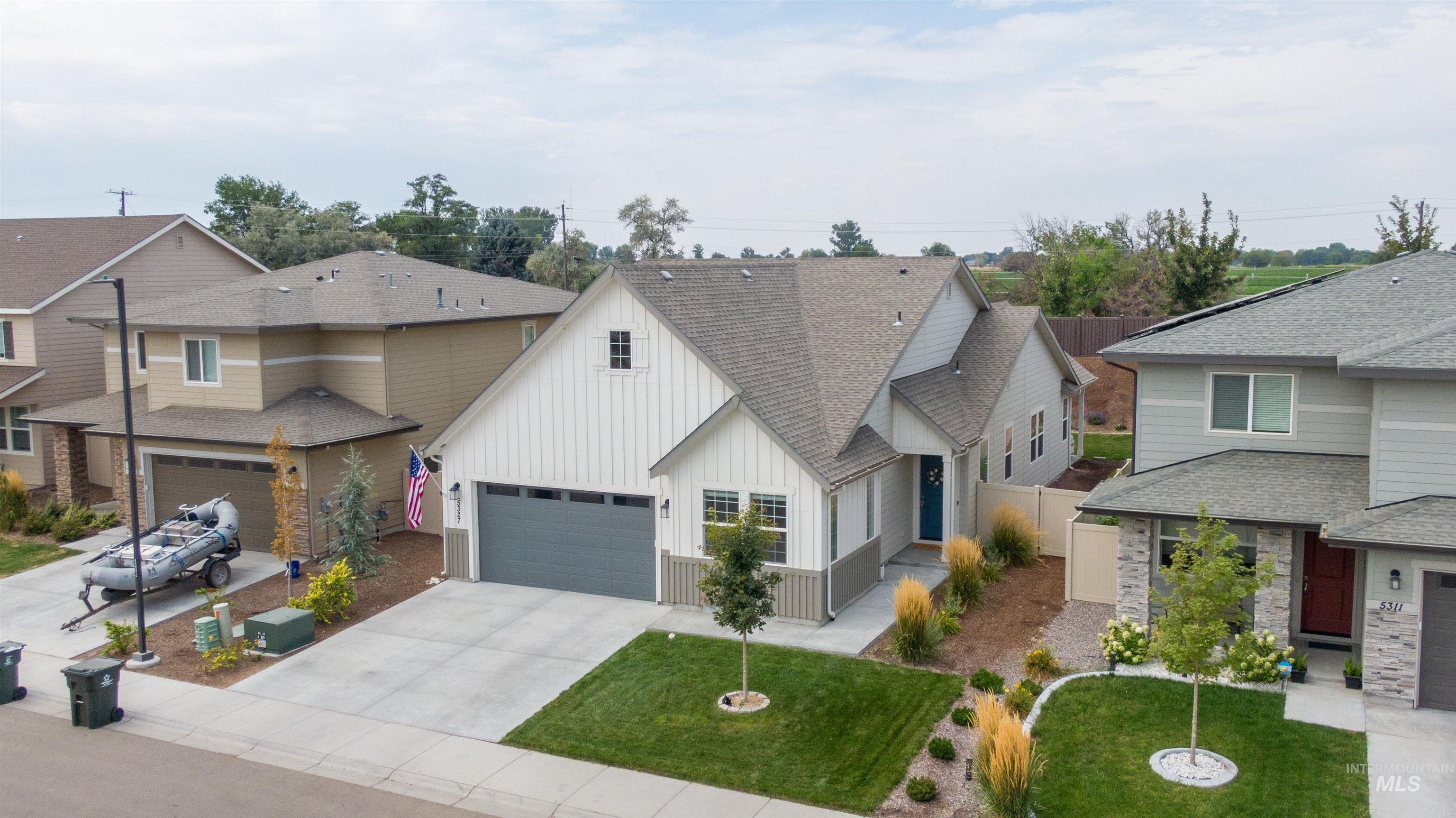 View of front of house featuring a shingled roof, board and batten siding, a garage, and concrete driveway