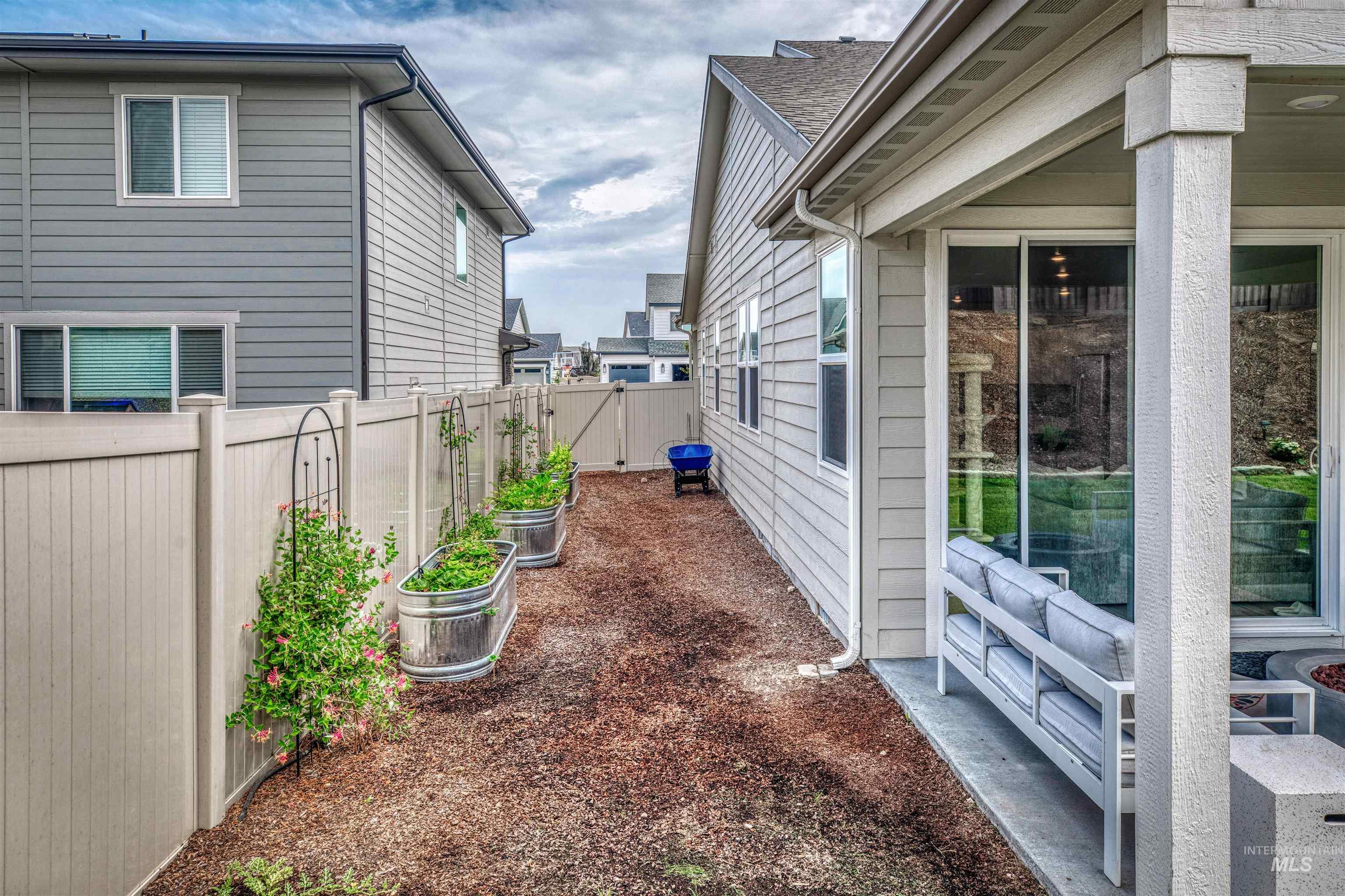 View of side of home featuring a fenced backyard and a garden