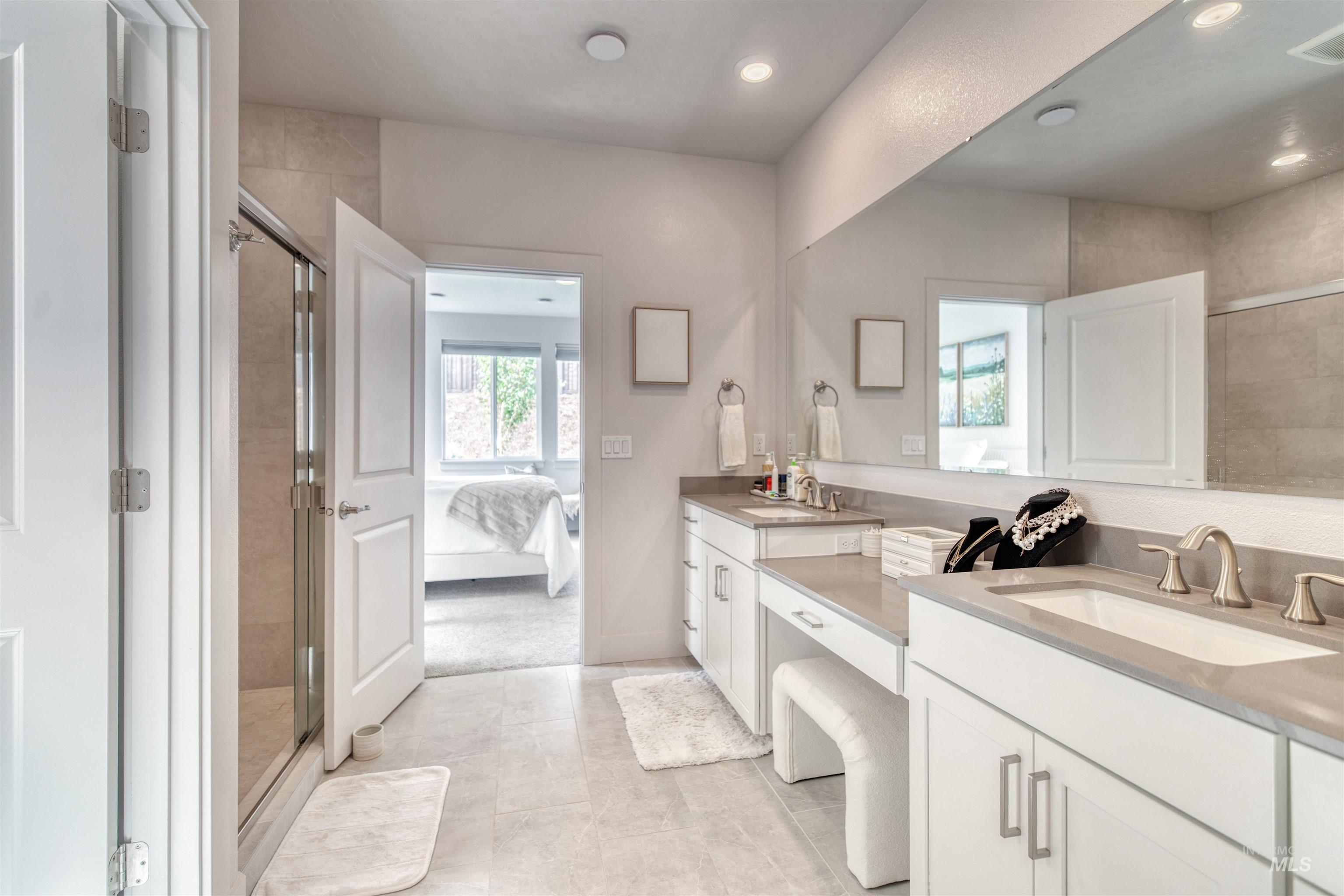 Bathroom featuring a shower stall, double vanity, ensuite bath, light tile patterned flooring, and recessed lighting