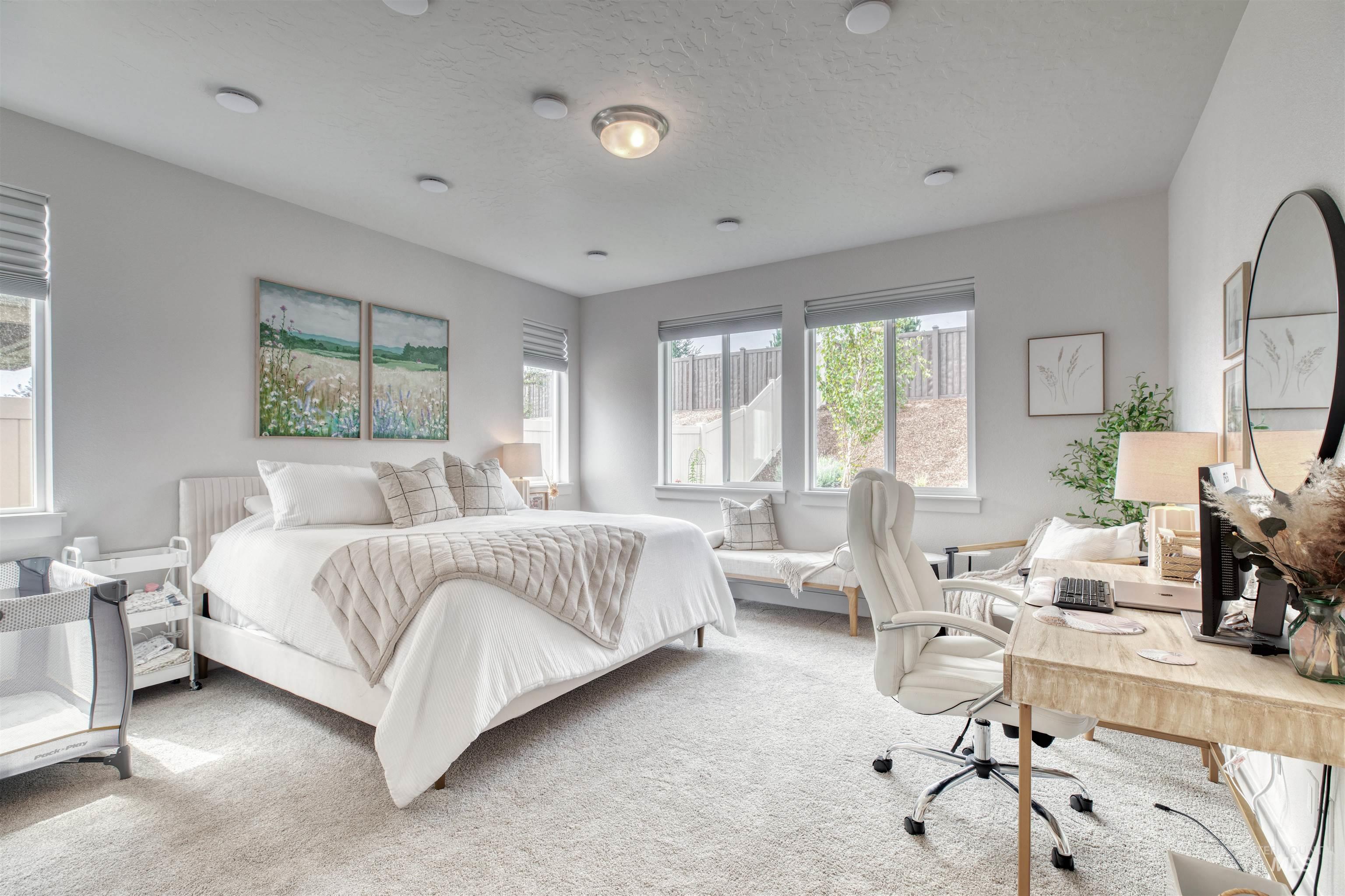 Carpeted bedroom with an office area and a textured ceiling