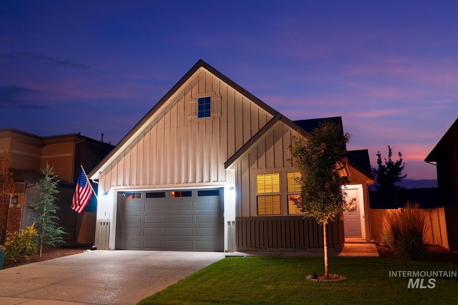 View of front of home featuring board and batten siding, a garage, and driveway