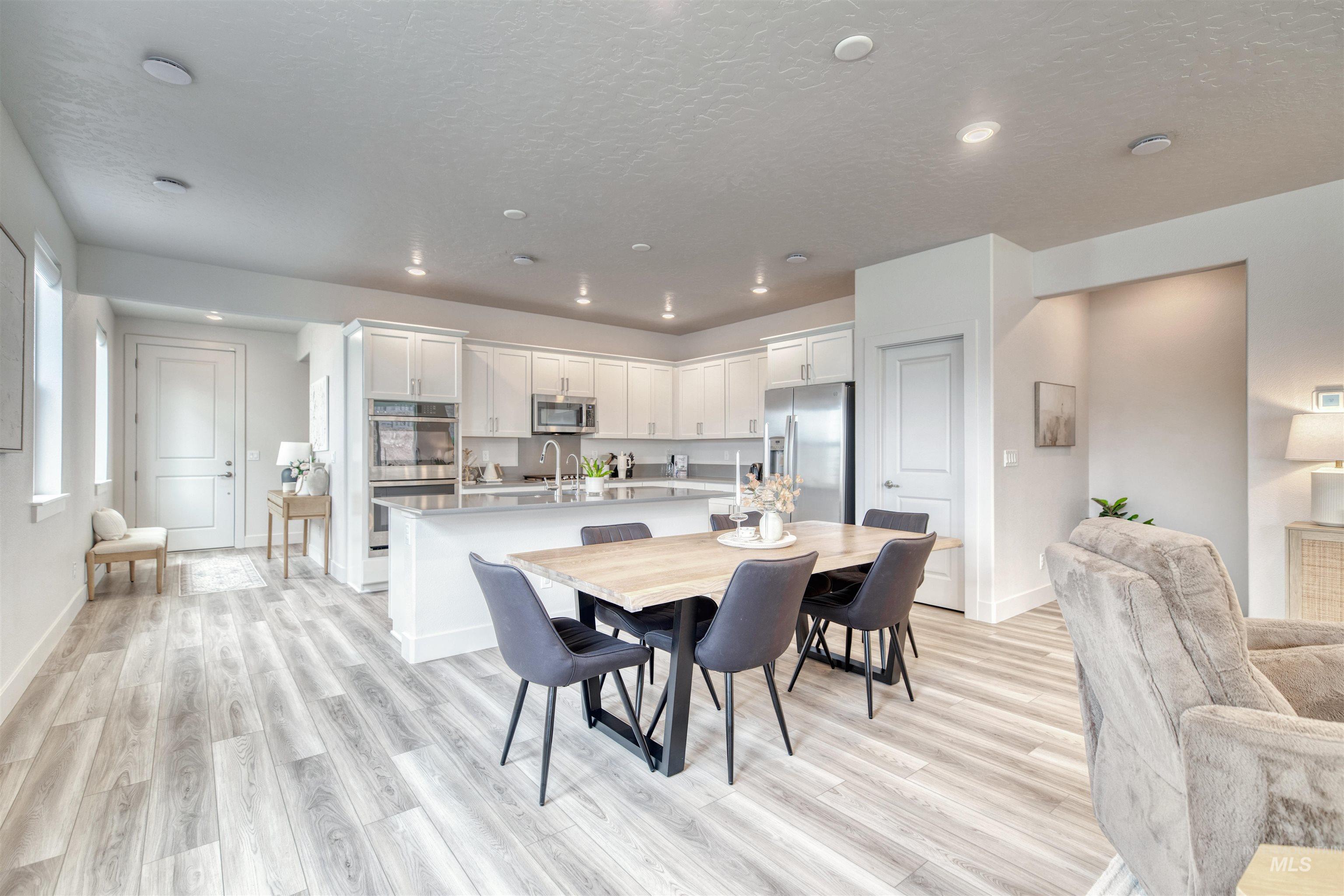 Dining space with light wood-style flooring, a textured ceiling, and recessed lighting