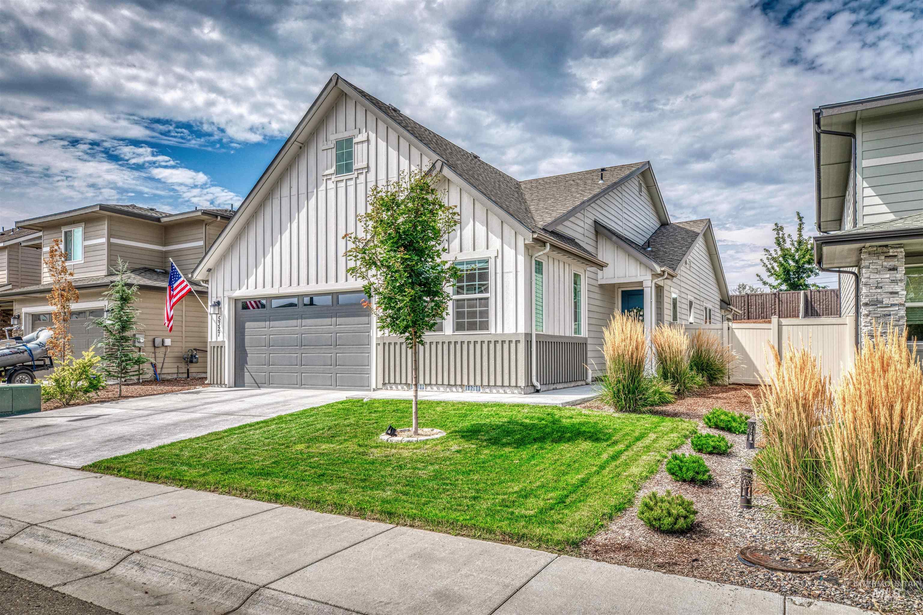 View of front of house featuring board and batten siding, driveway, a garage, and roof with shingles