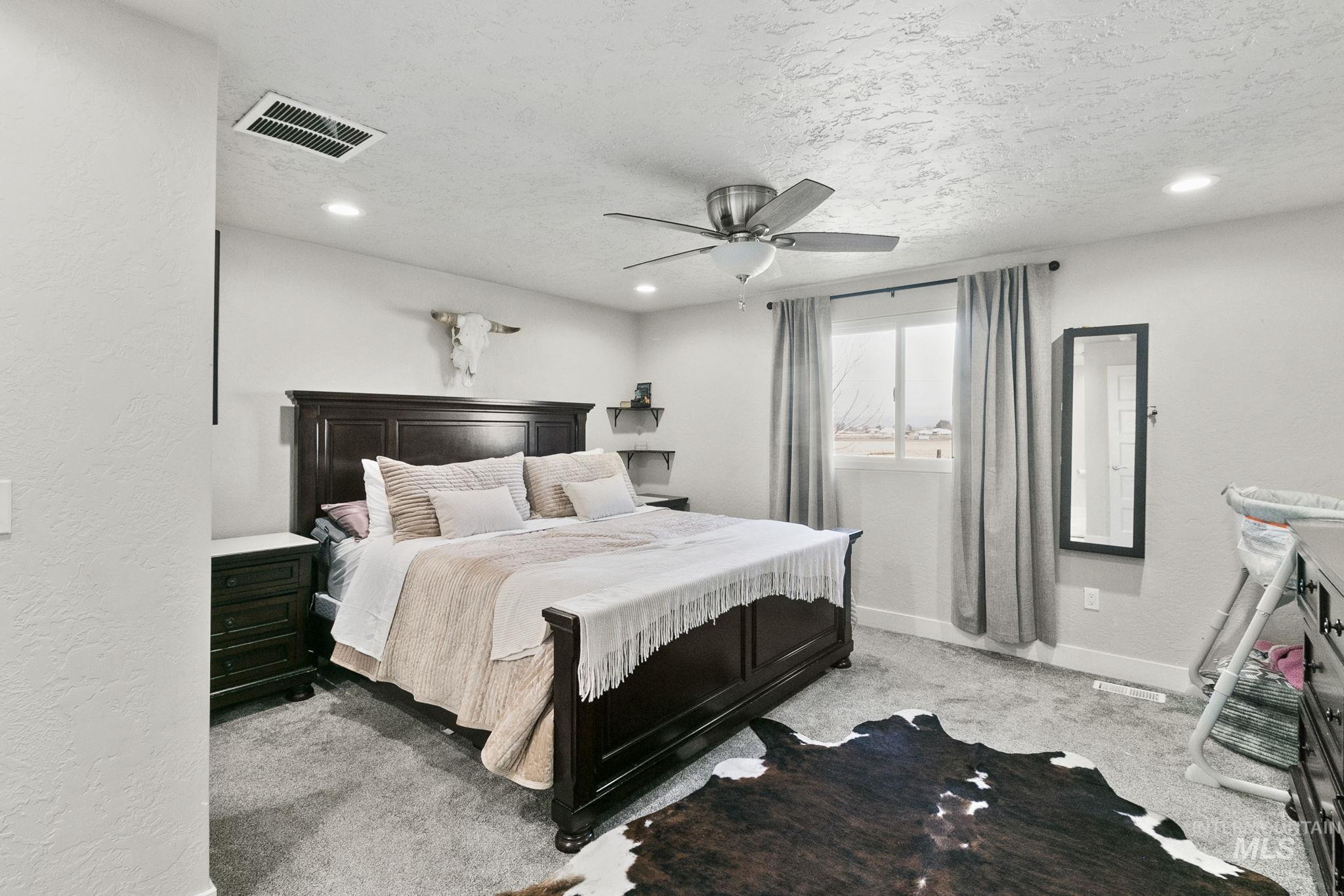Bedroom featuring carpet flooring, a textured ceiling, a textured wall, a ceiling fan, and recessed lighting