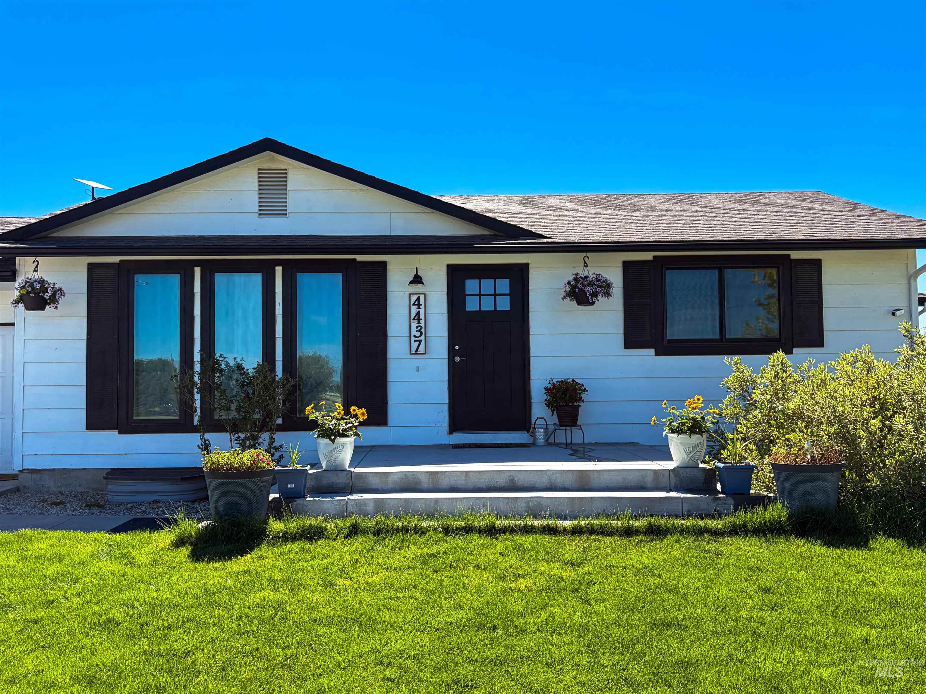 White siding exterior with a dark trim roofline