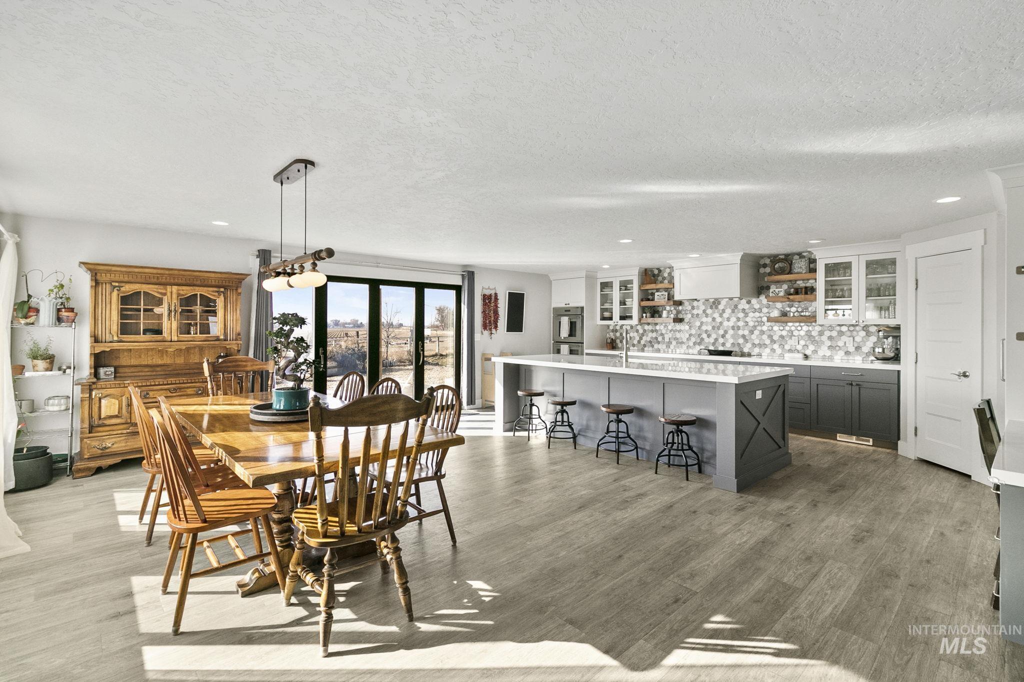 Dining room with recessed lighting, light wood finished floors, and a textured ceiling