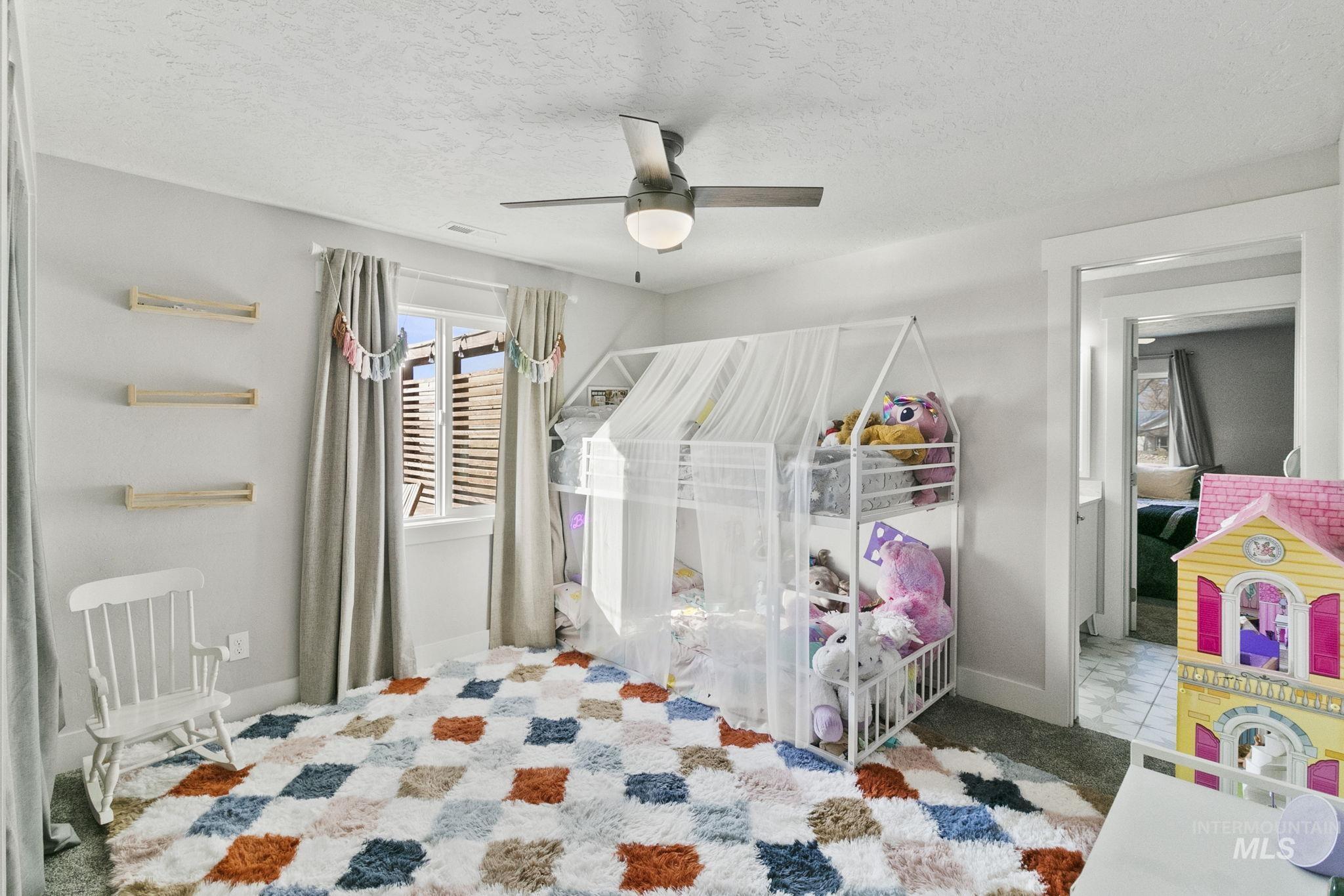 Bedroom featuring a ceiling fan and a textured ceiling